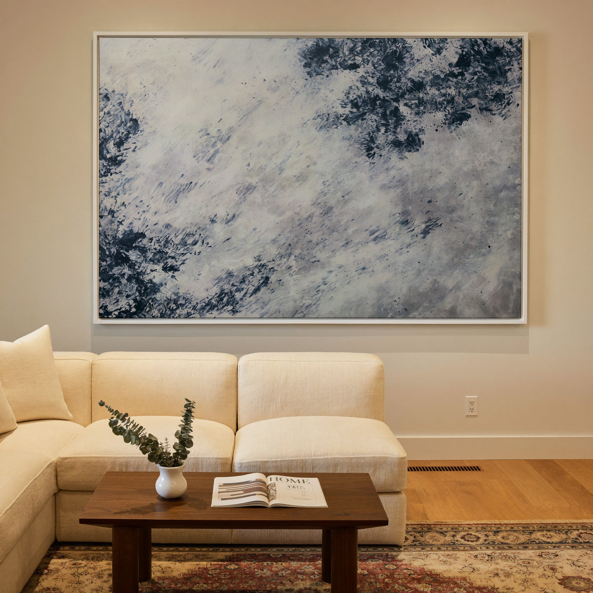 soft black and blue abstract with scattered canvas wall art in a white frame in a styled room setting