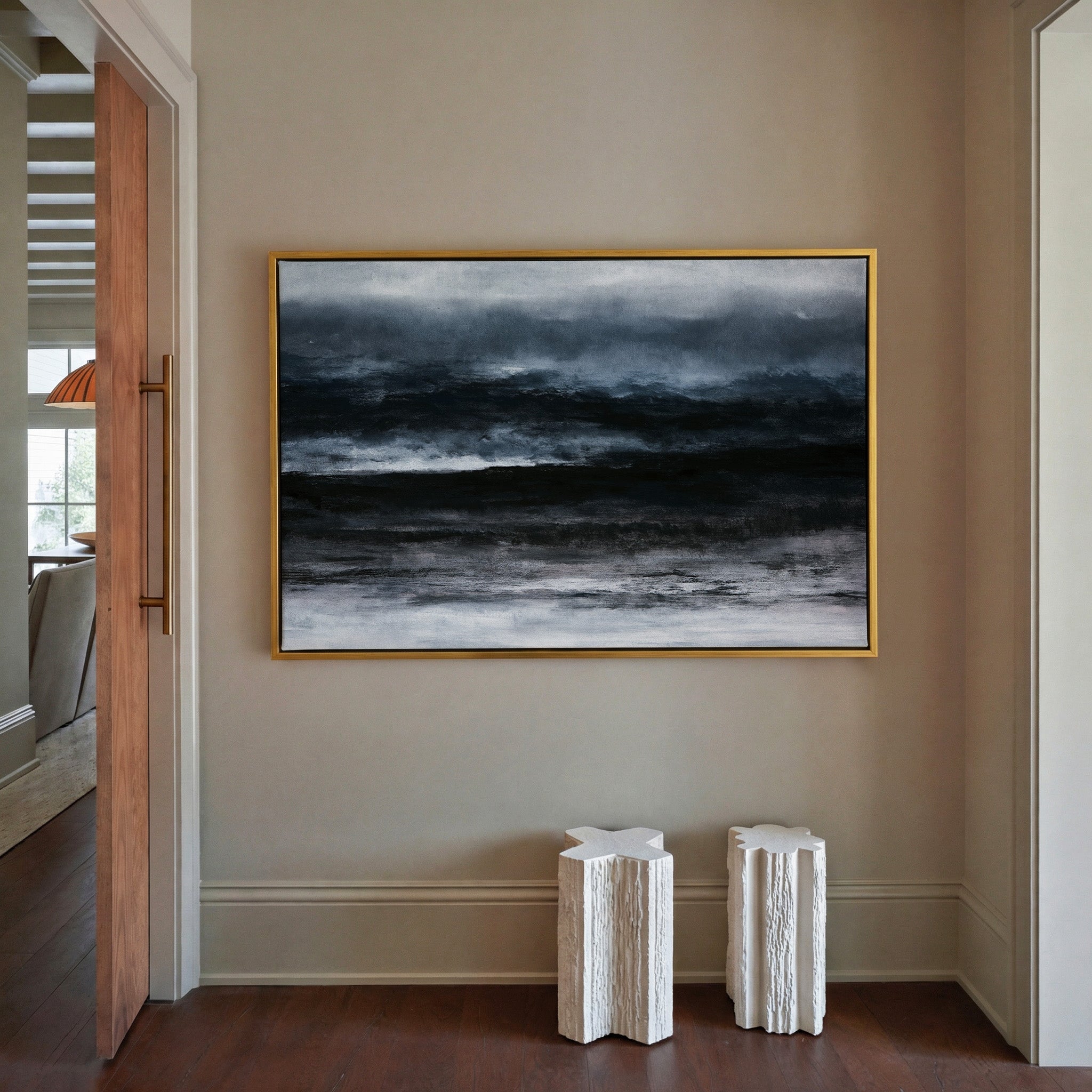 dark black and navy abstract with layered canvas wall art in a gold frame in a styled room setting