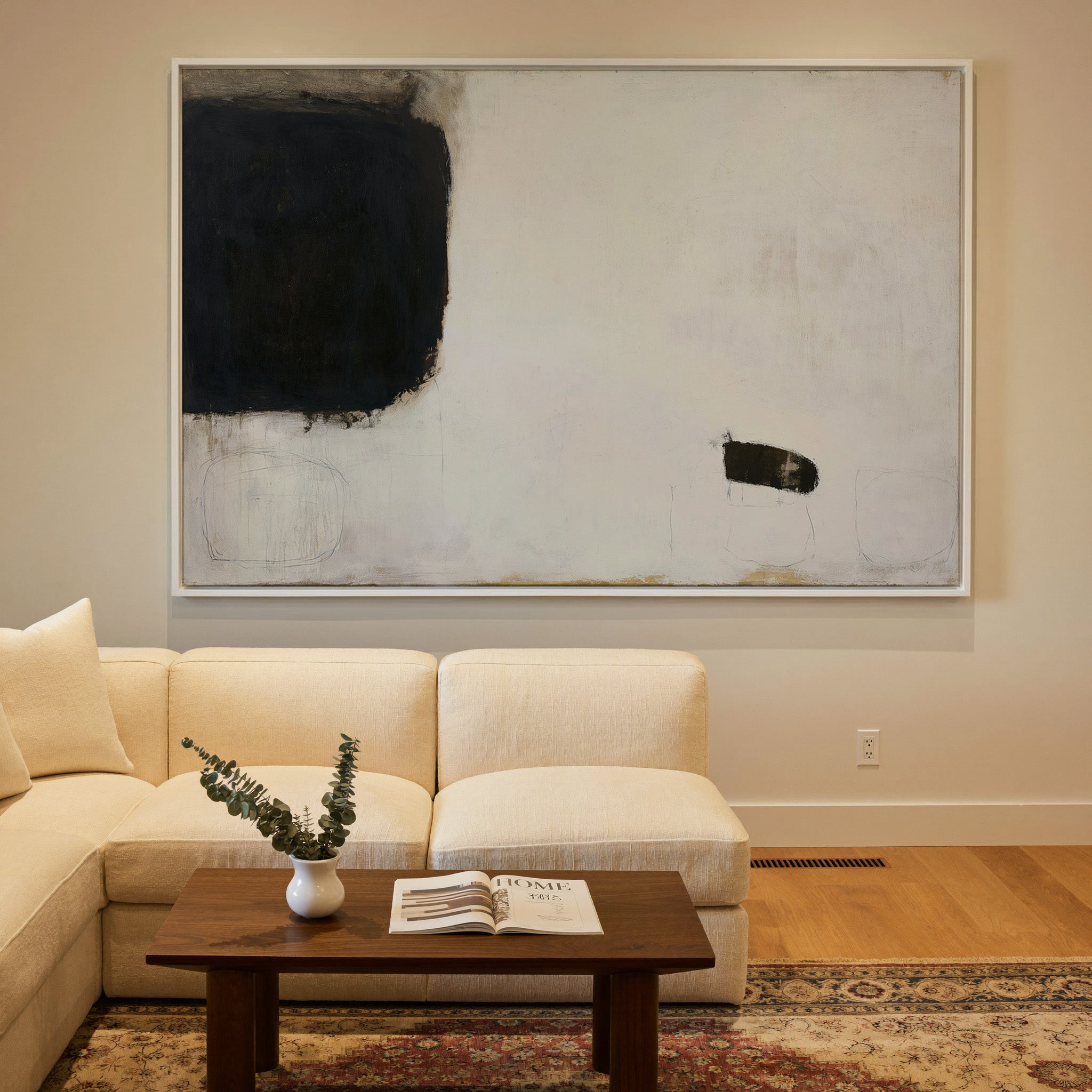 sparse black and cream abstract with heavy dark canvas wall art in a white frame in a styled room setting