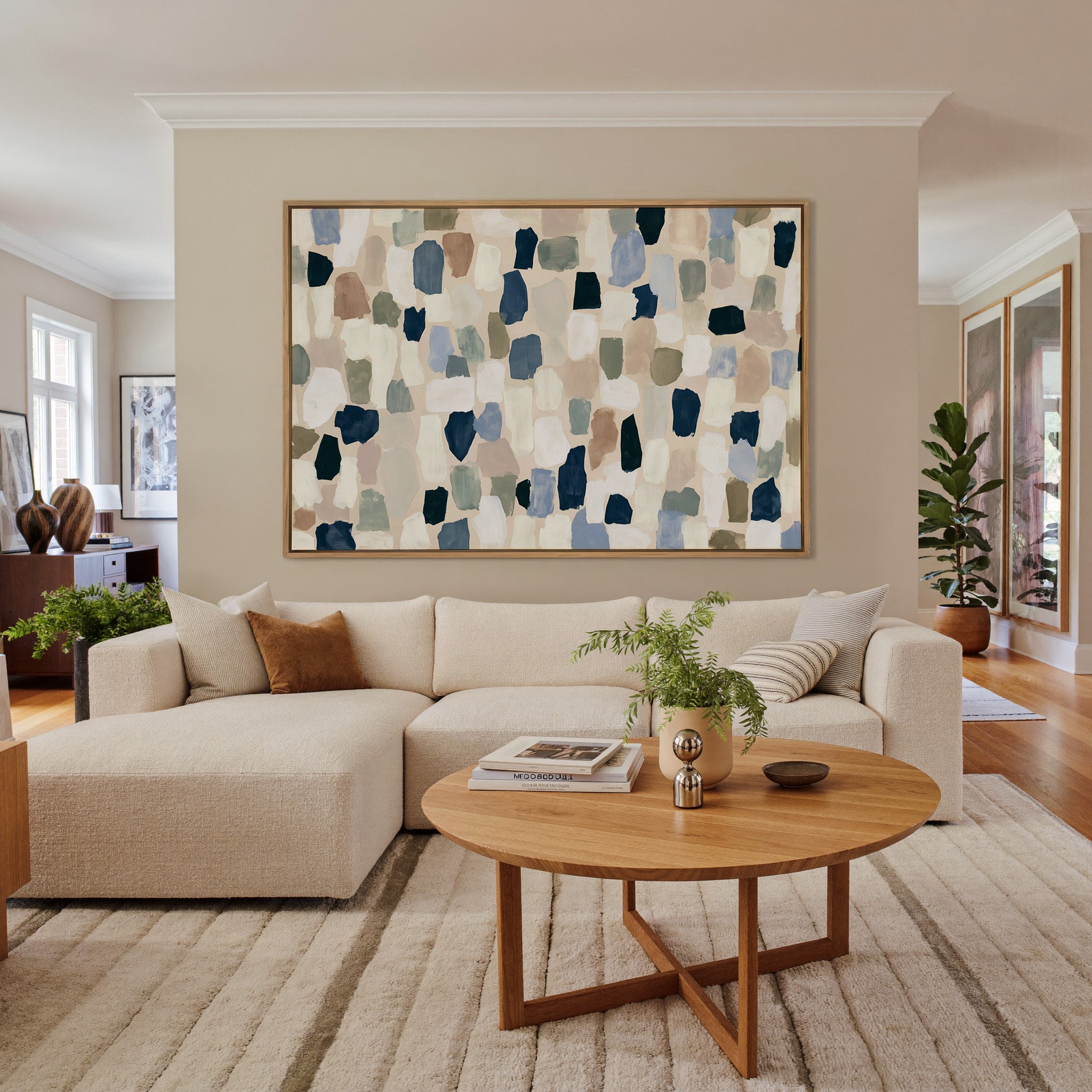 warm stone abstract with drifting hand cut canvas wall art in an oak frame in a living room
