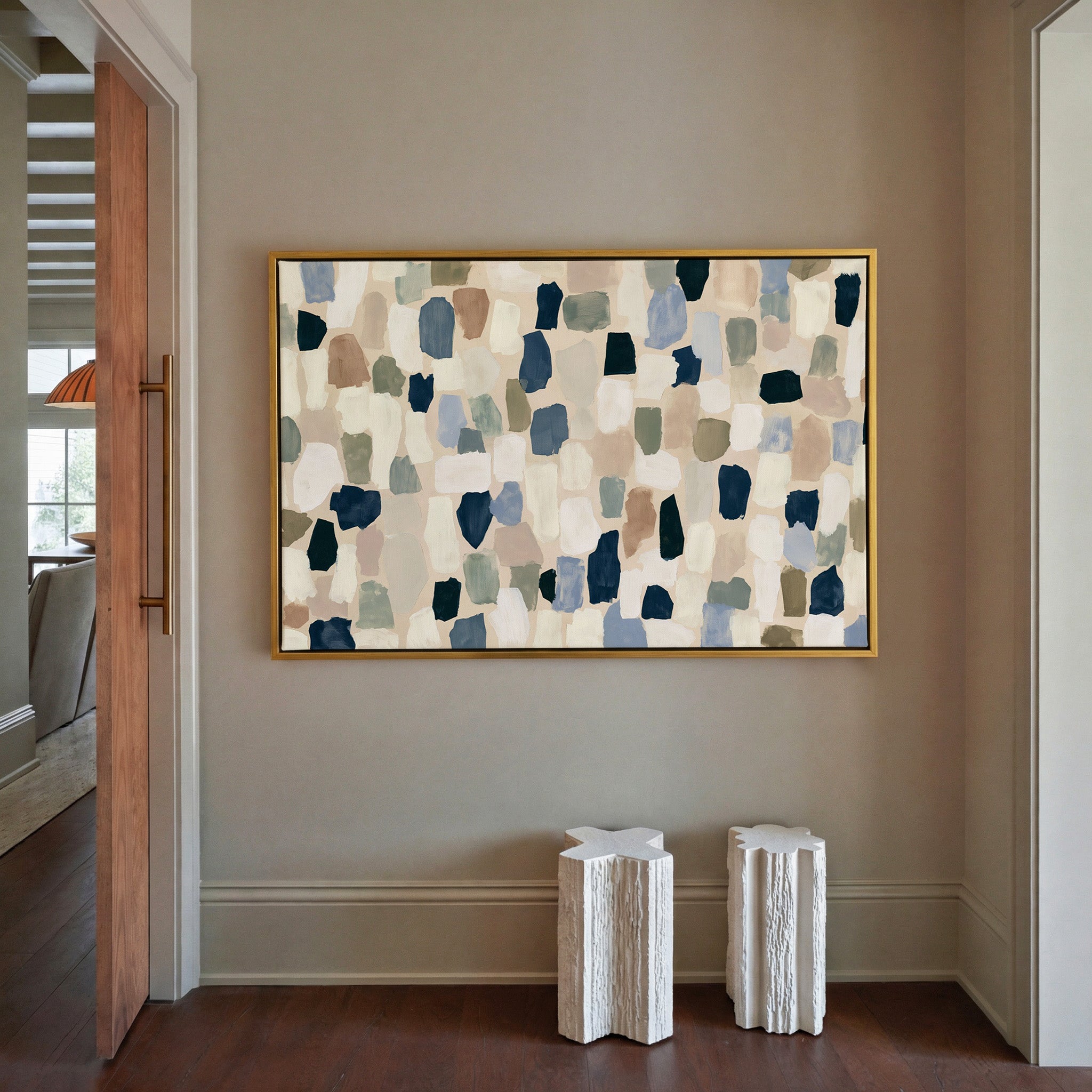 warm stone abstract with drifting hand cut canvas wall art in a gold frame in a styled room setting