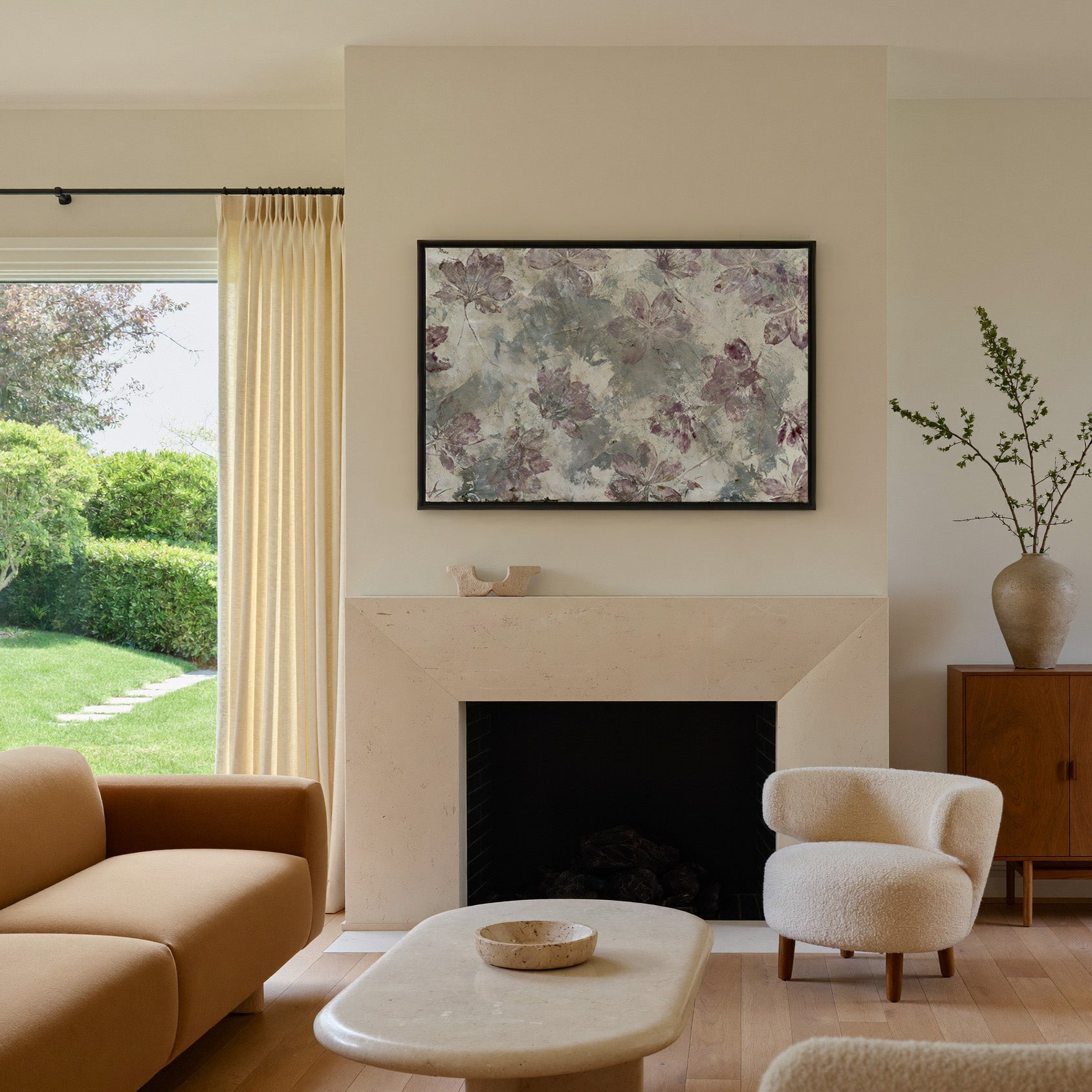 muted floral abstract with mauve blossoms on a canvas wall art in a black frame above a mantel