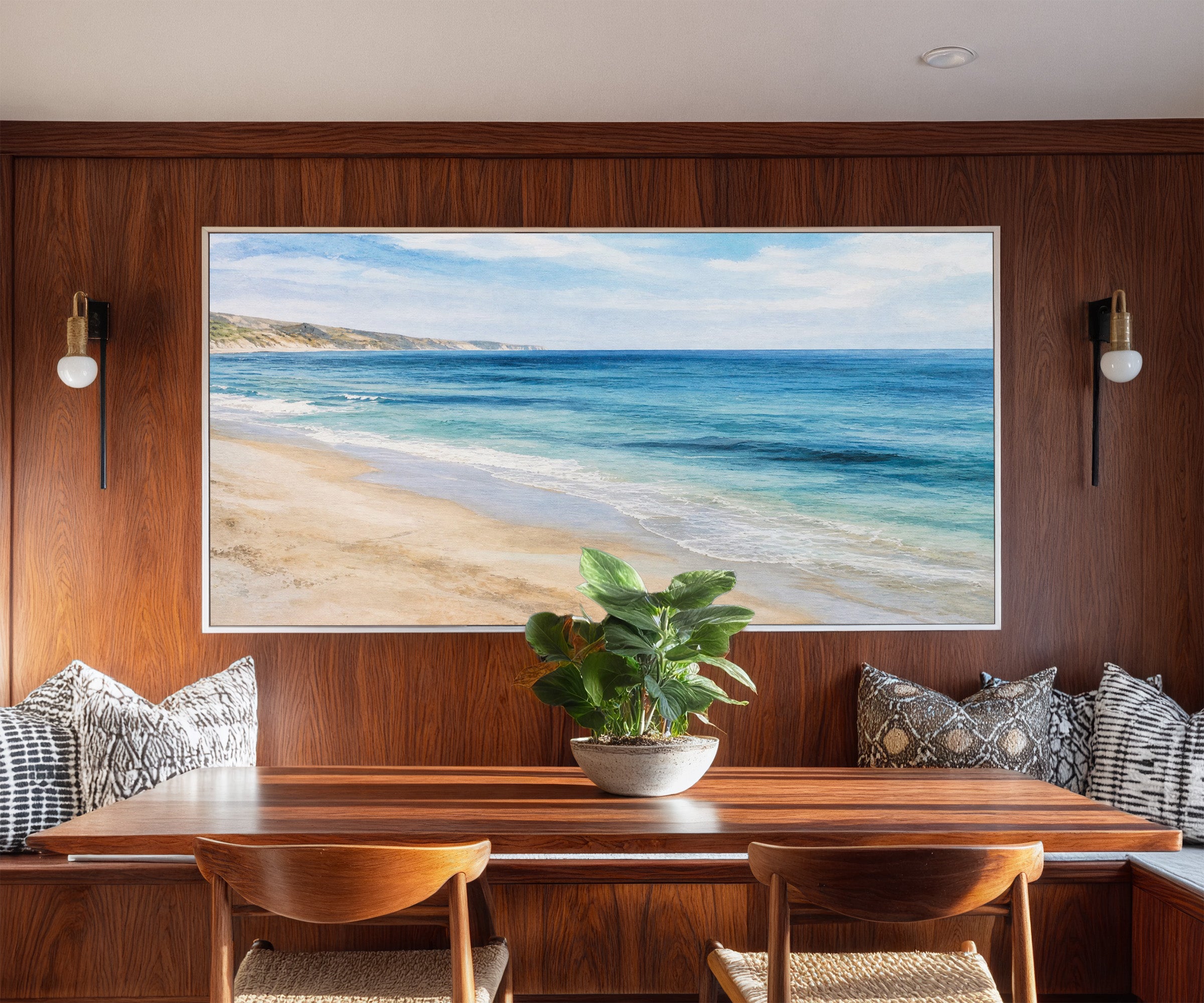 blue sea with pale sand and distant headland canvas wall art in a white frame in a styled room setting