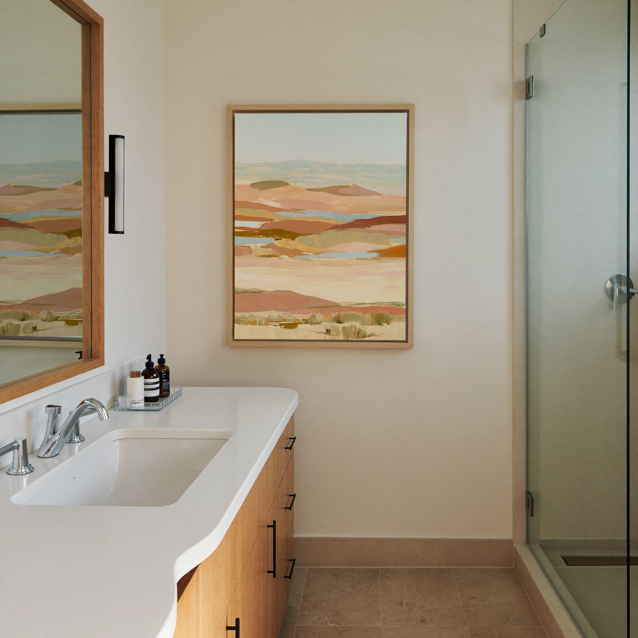 soft desert hills in blush, sand, blue, and canvas wall art in a natural wood frame in a styled room setting