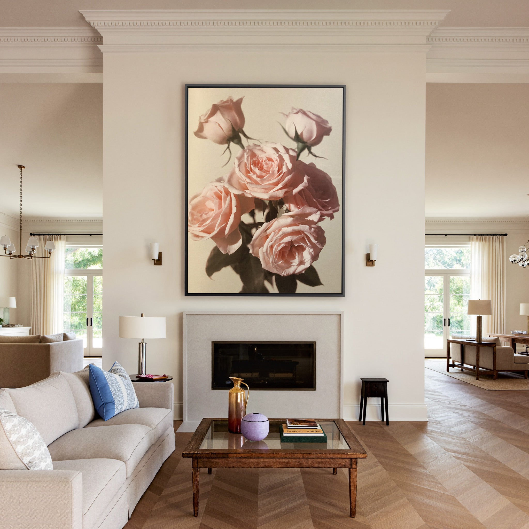 soft pink roses with dark leaves on a pale canvas wall art in a black frame above a mantel