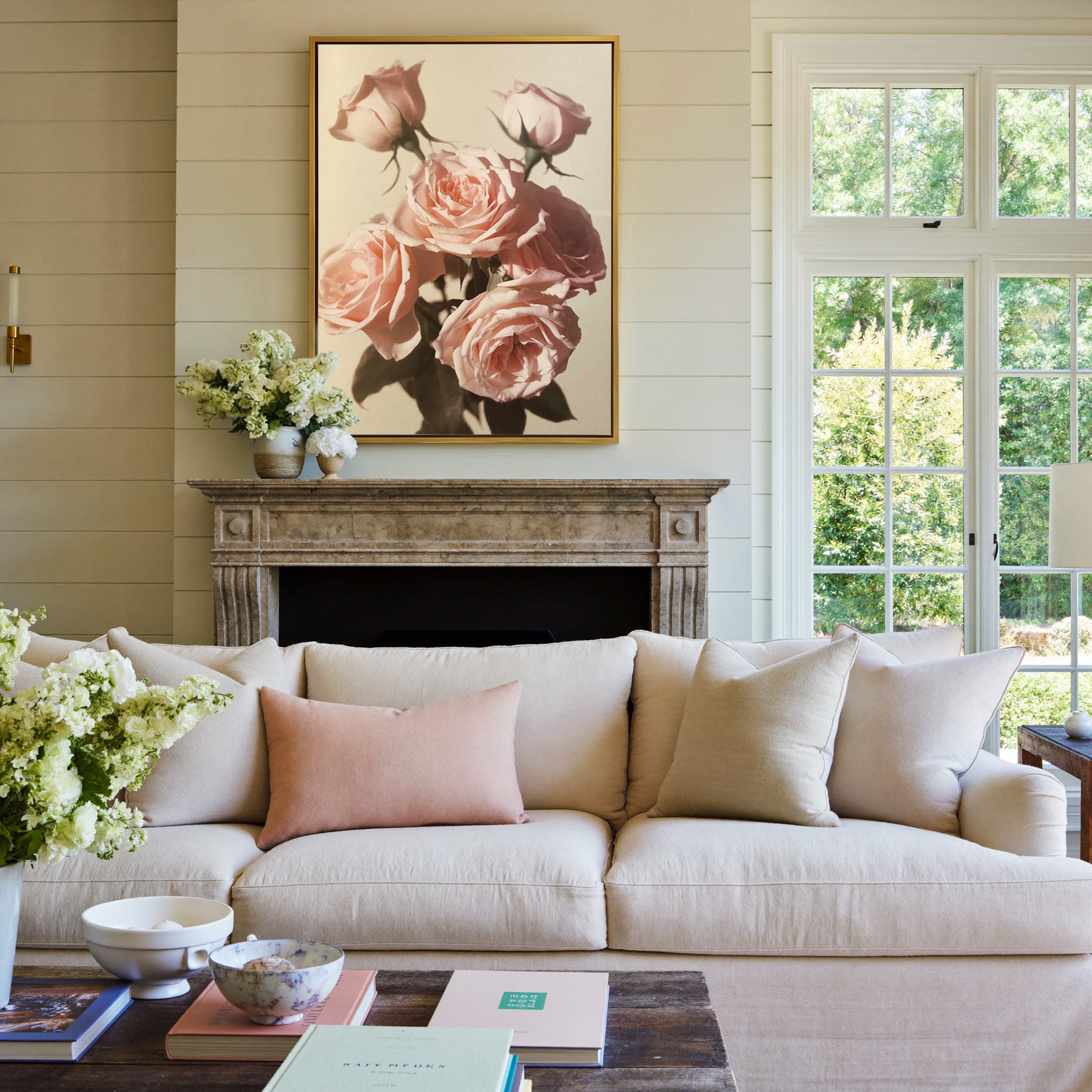 soft pink roses with dark leaves on a pale canvas wall art in a gold frame above a mantel