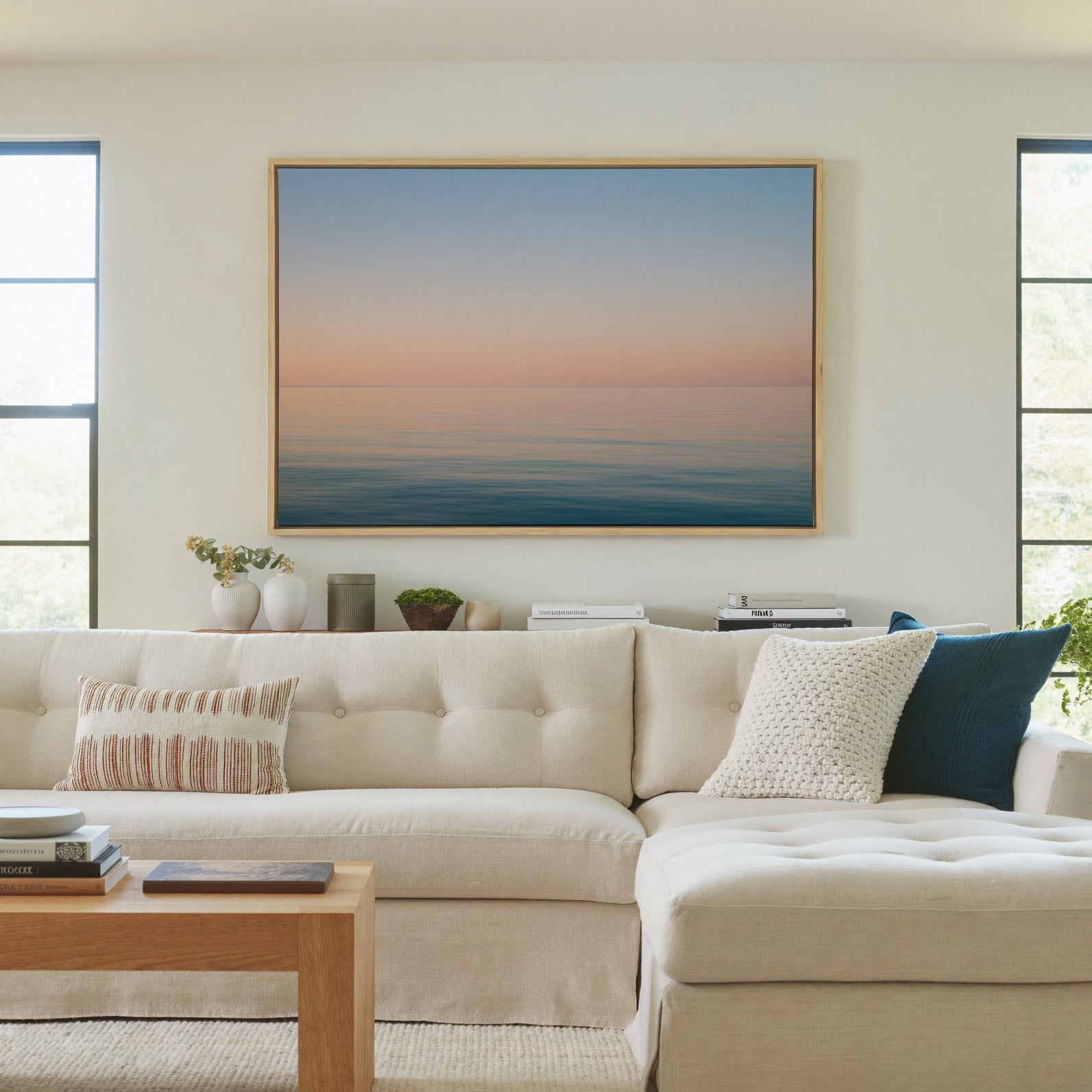 soft pastel sea and sky seascape canvas wall art in a natural wood frame in a living room