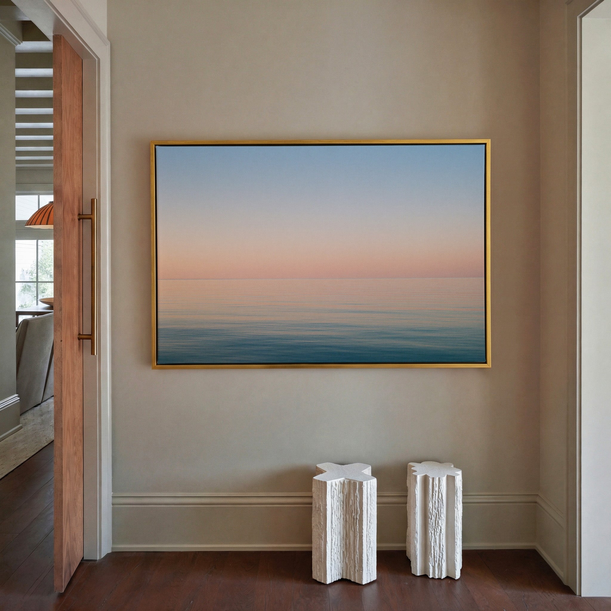 soft pastel sea and sky seascape canvas wall art in a gold frame in a styled room setting