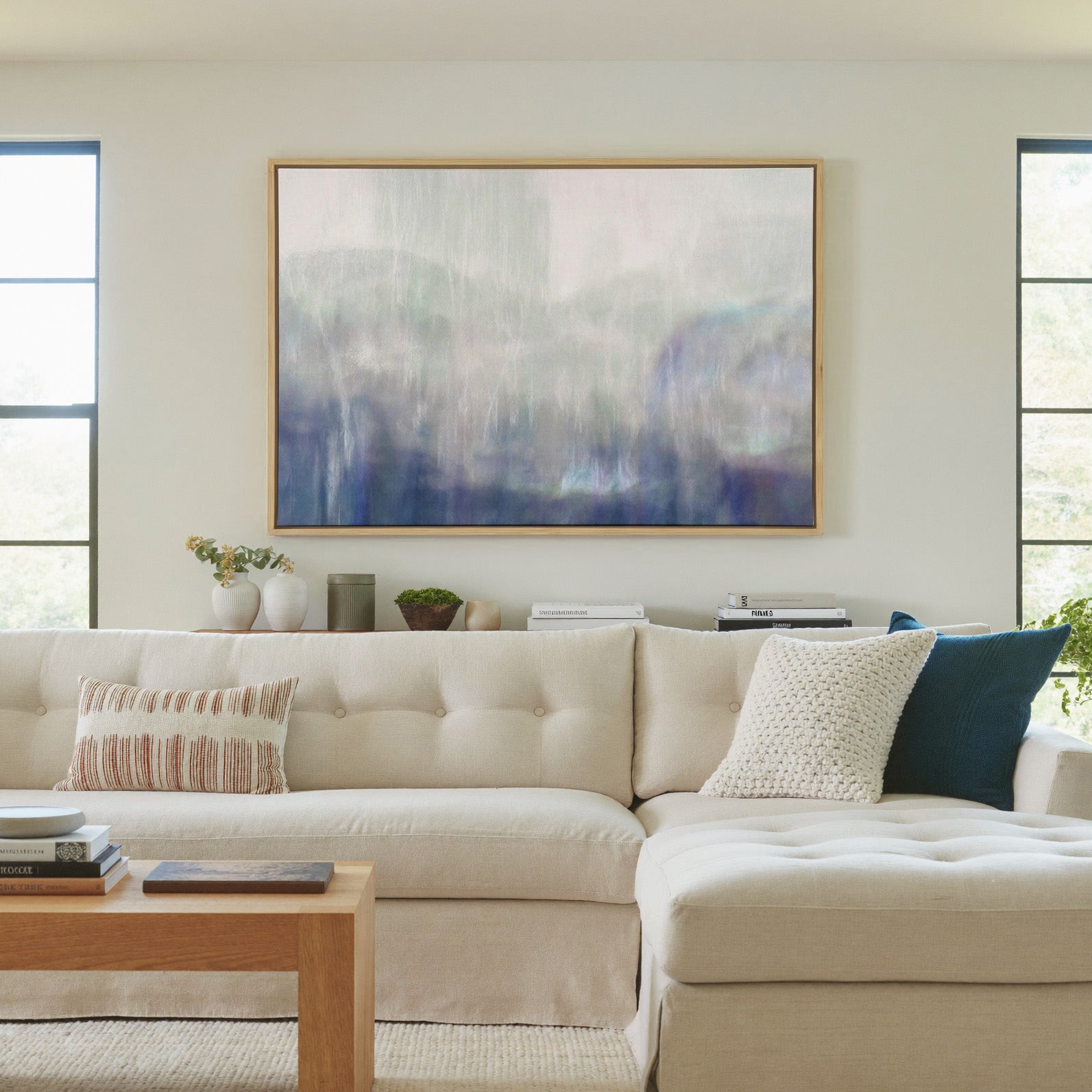 soft blue and violet abstract canvas wall art in a natural wood frame in a living room