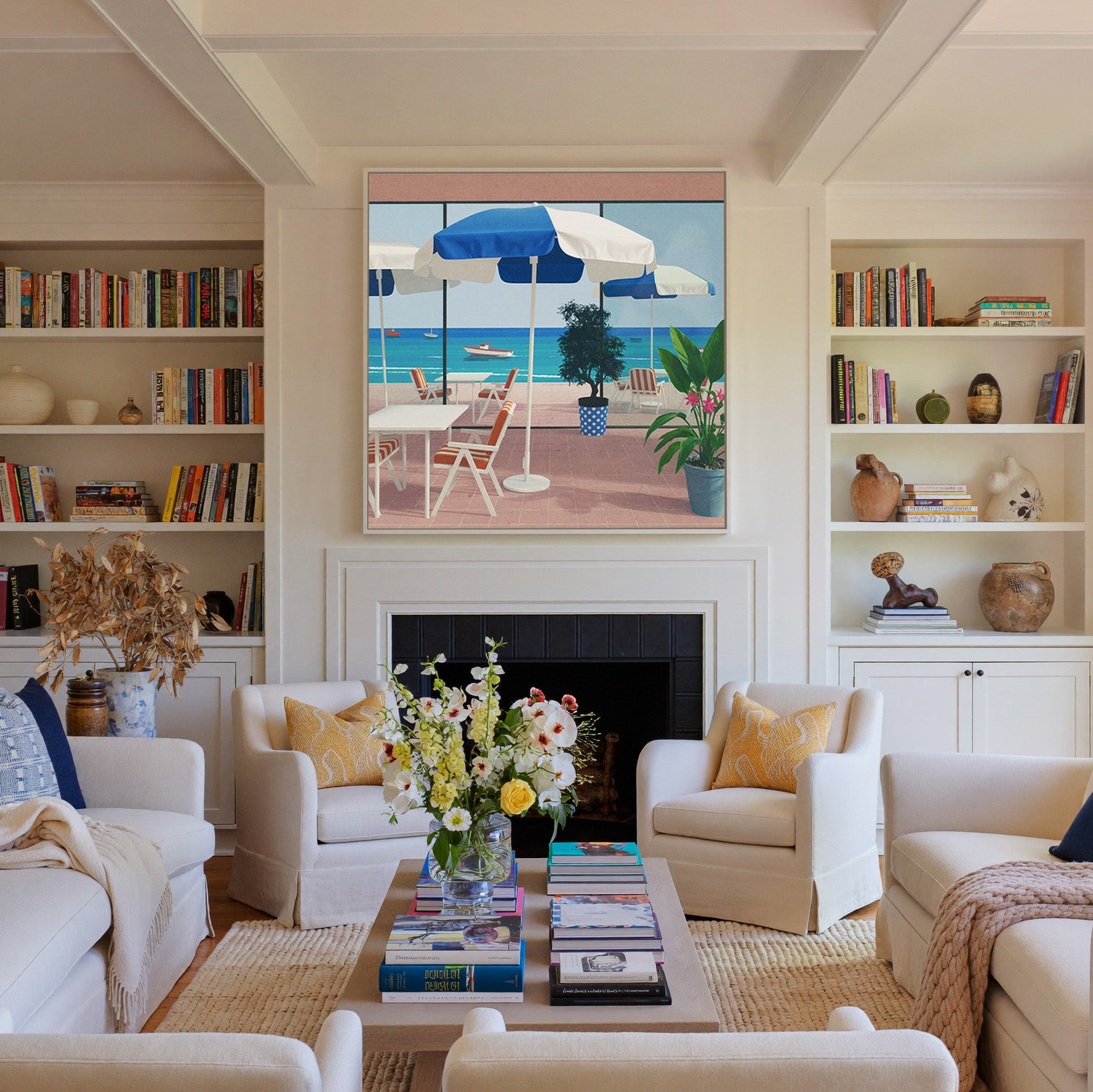 blue umbrellas and striped chairs by the sea canvas wall art in a white frame above a fireplace