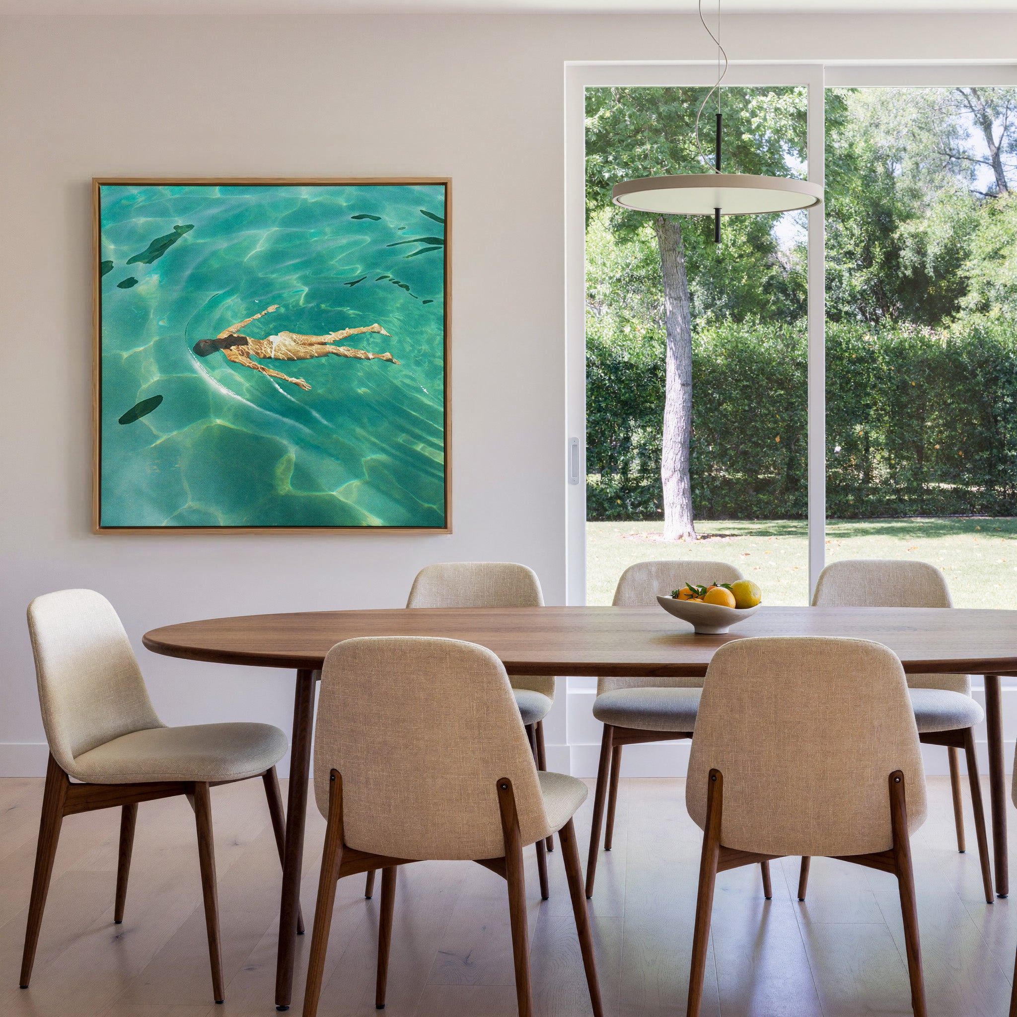 overhead swimmer in turquoise water canvas wall art in an oak frame in a dining room