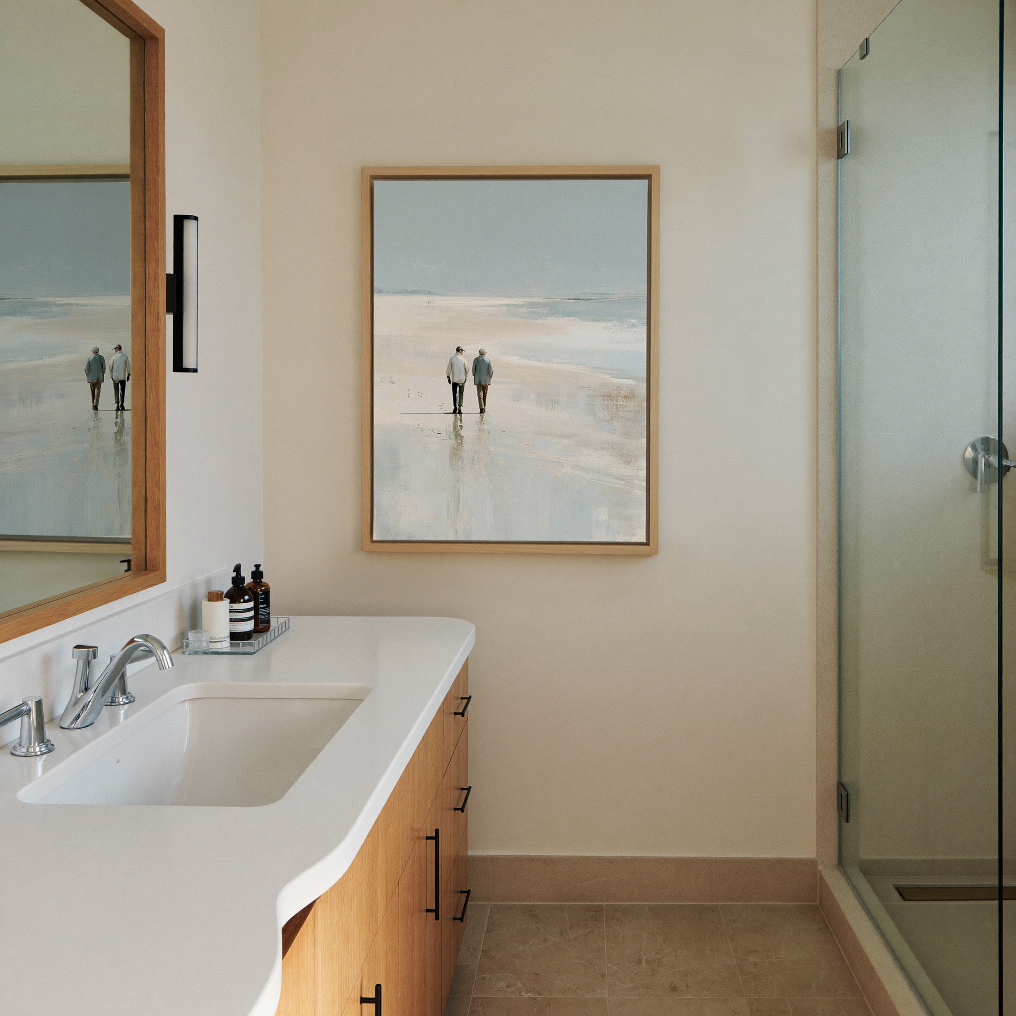 pale beach with two figures and canvas wall art in a natural wood frame in a styled room setting