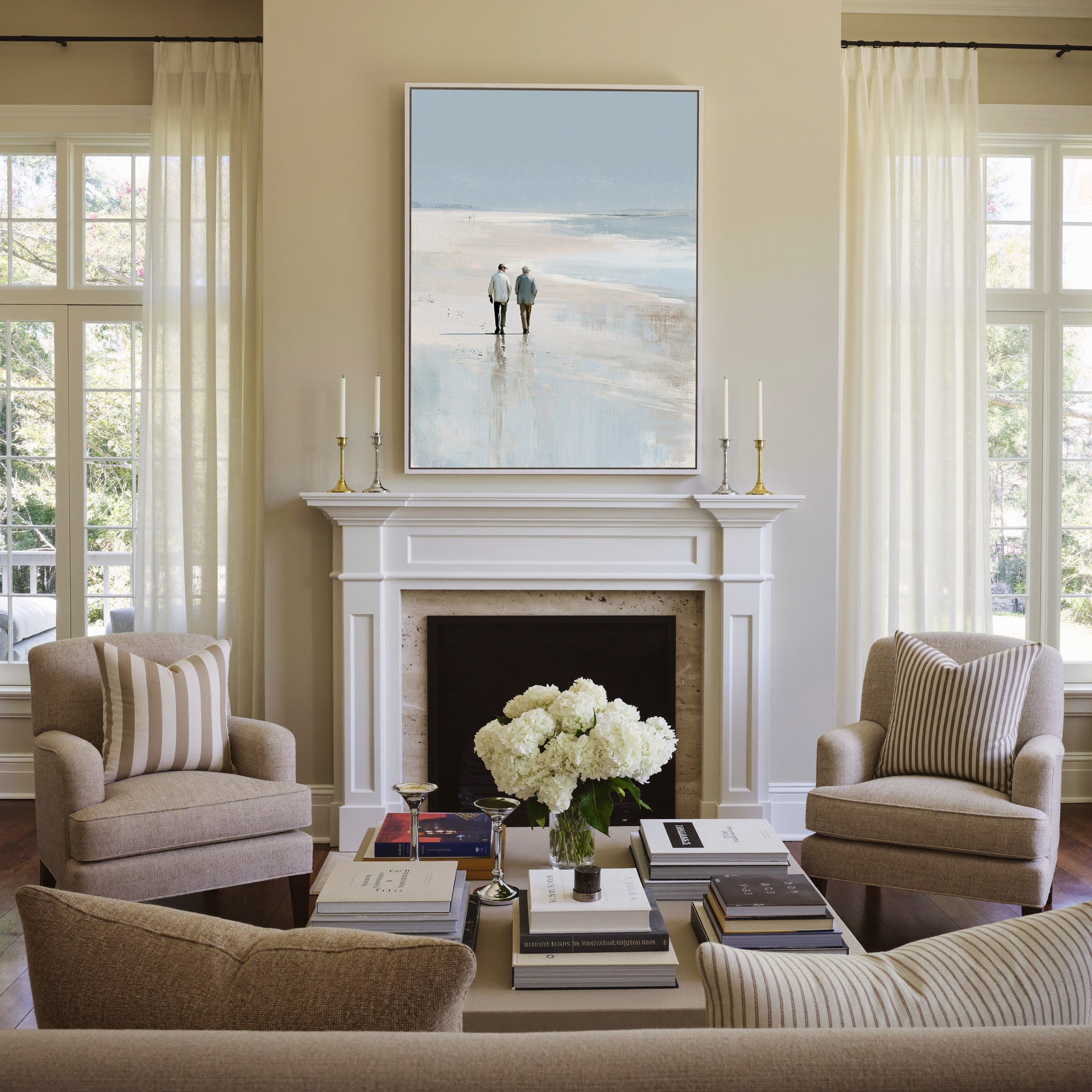 pale beach with two figures and soft blue water canvas wall art in a white frame above a mantel