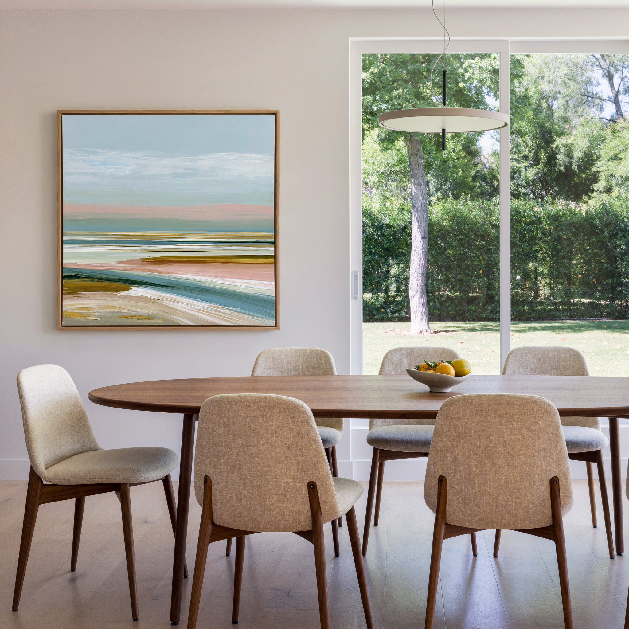 layered seafoam, blush, and sand bands canvas wall art in an oak frame in a dining room
