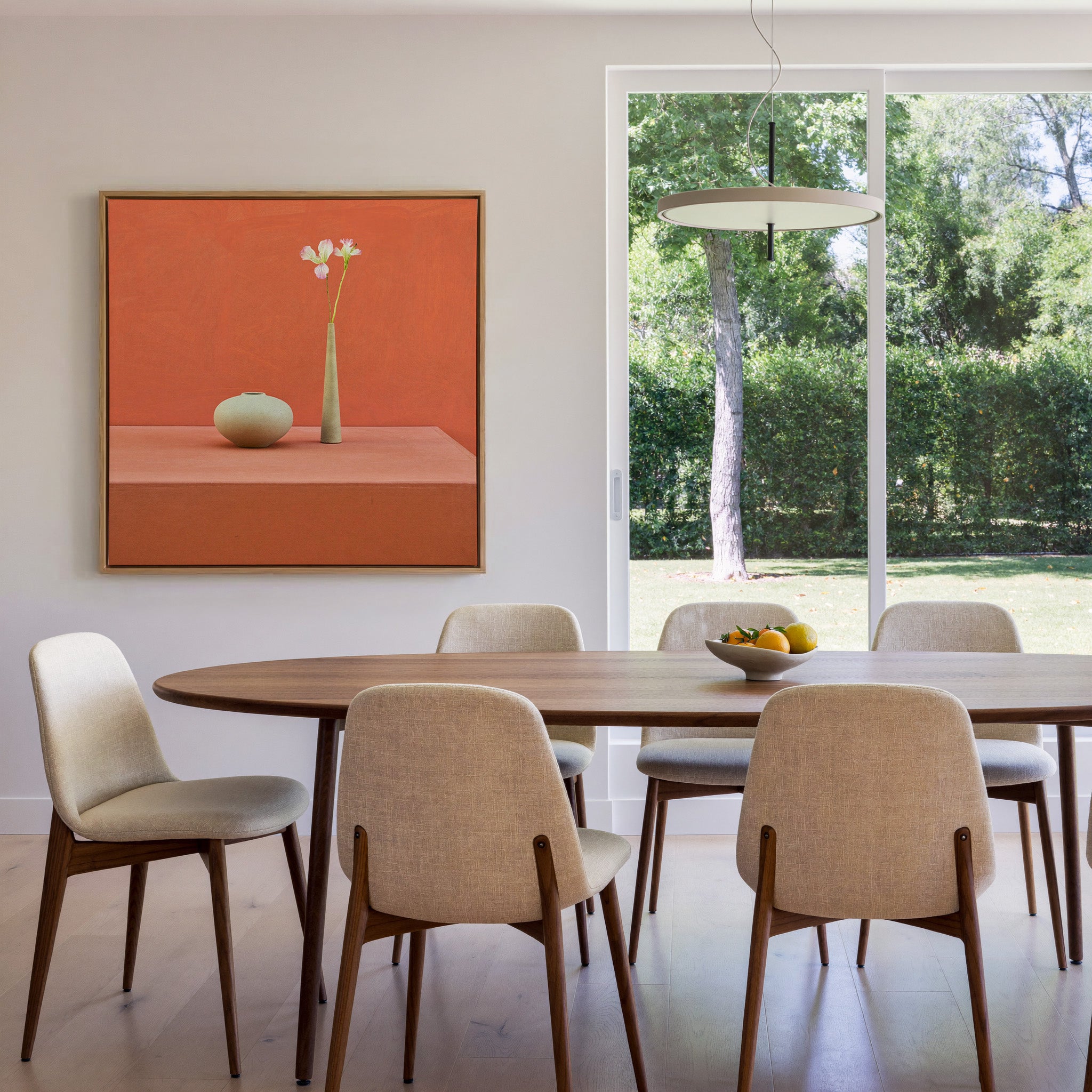 terracotta still life with vase and single stem canvas wall art in an oak frame in a dining room