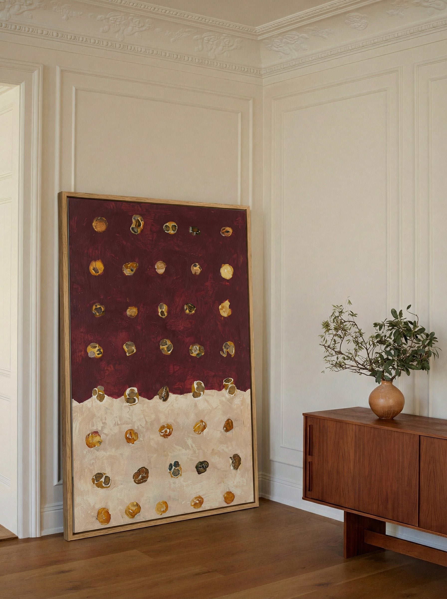 burgundy and cream abstract with scattered canvas wall art in an oak frame in a styled room setting