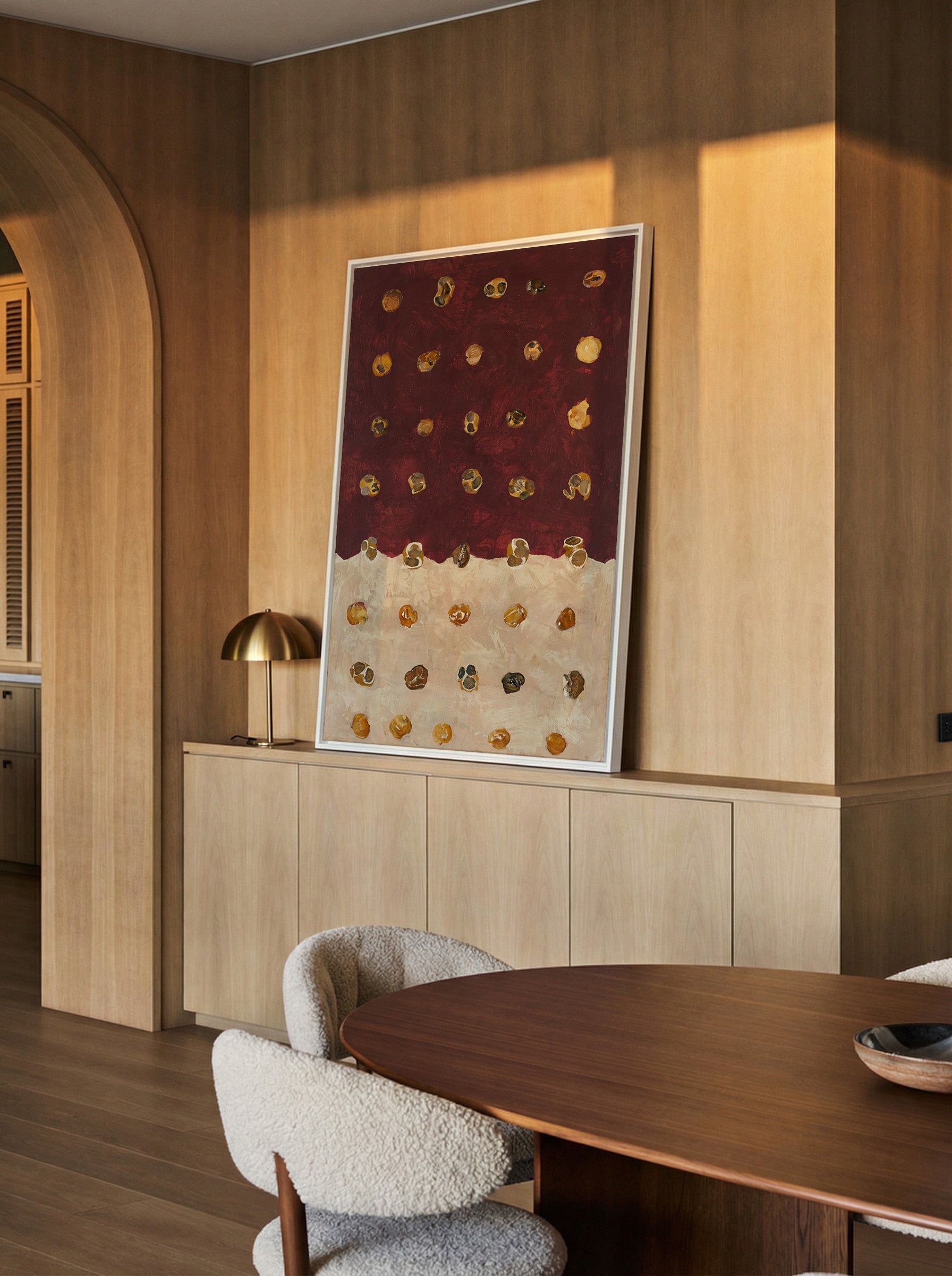 burgundy and cream abstract with scattered canvas wall art in a white frame in a styled room setting