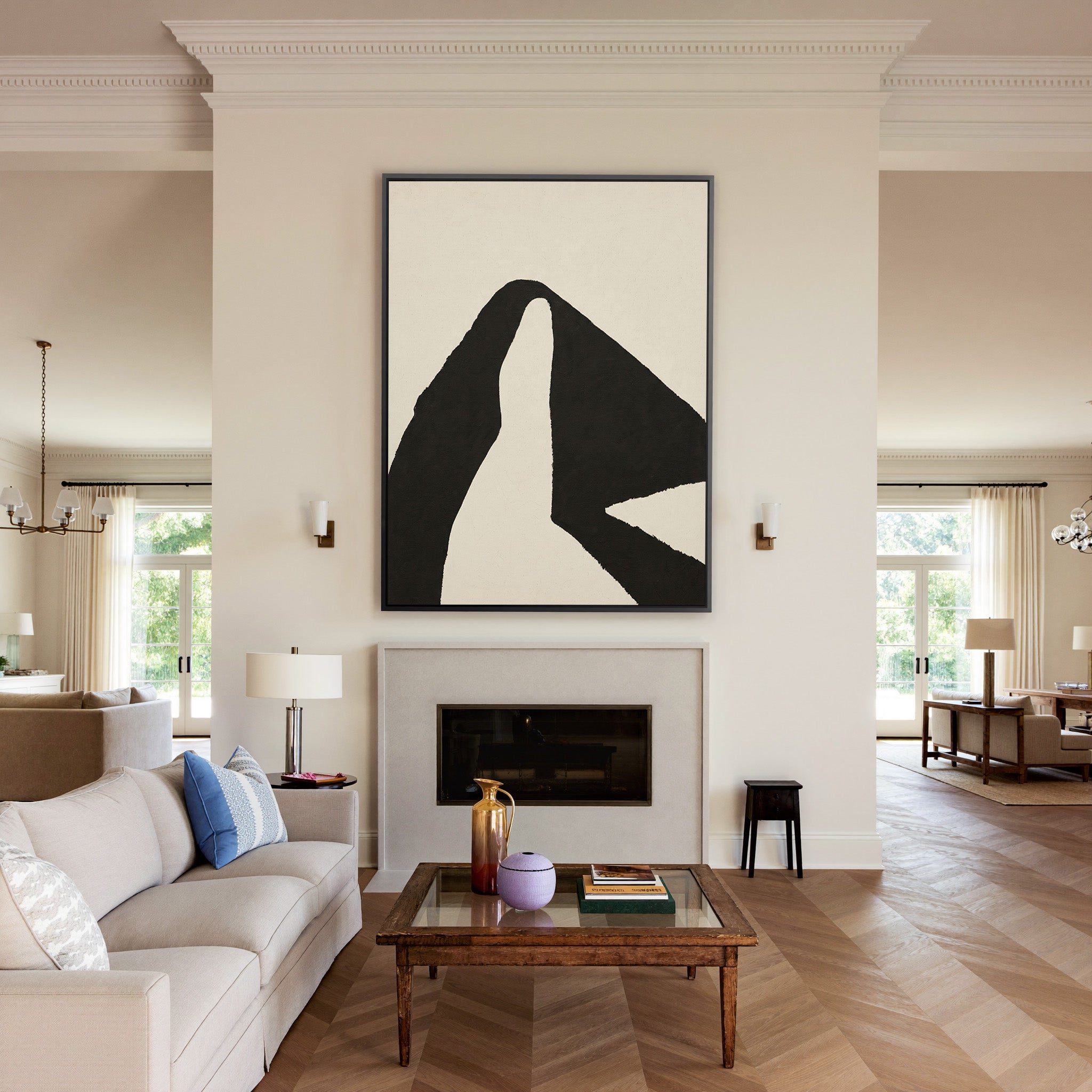 black and cream abstract with sweeping angular canvas wall art in a black frame above a mantel