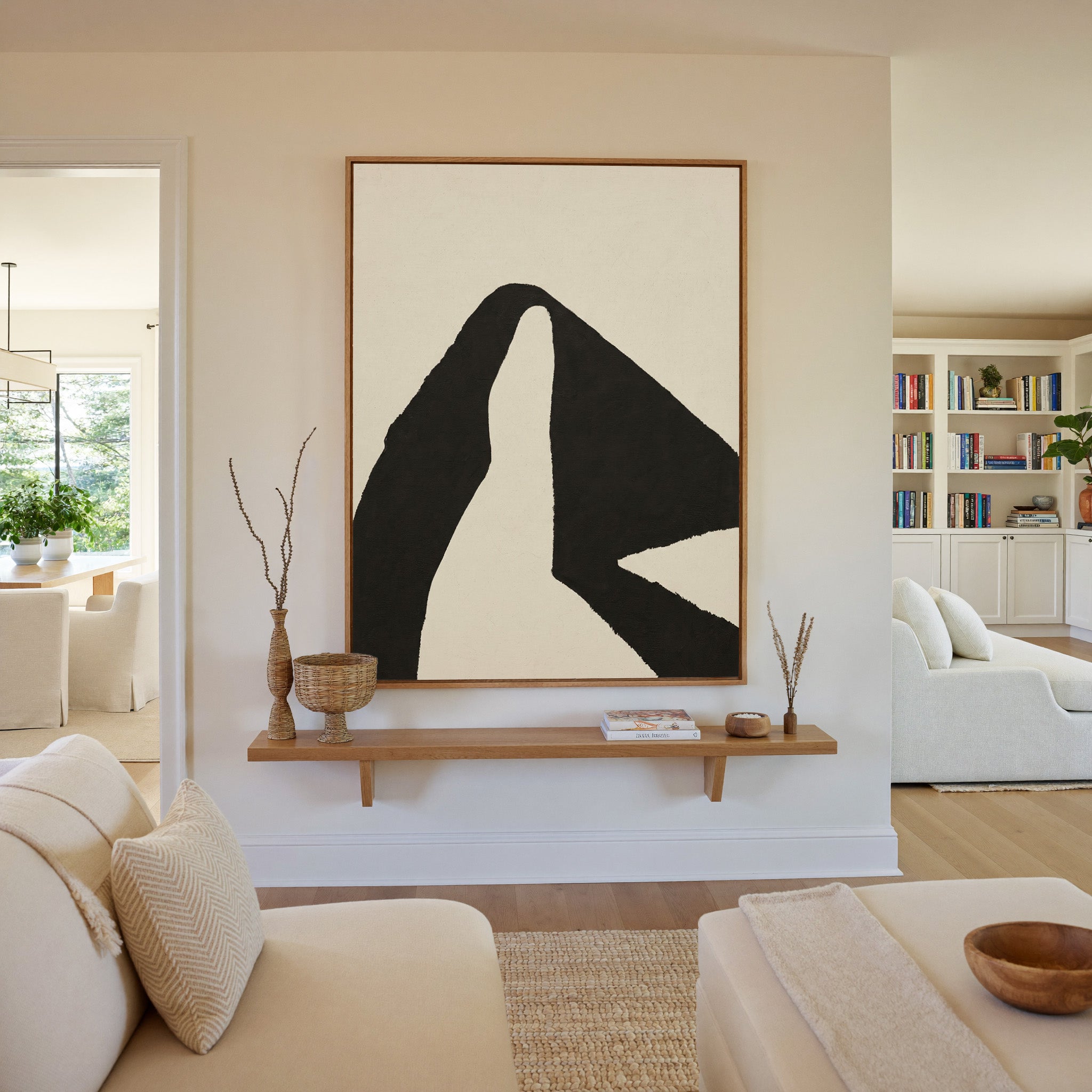 black and cream abstract with sweeping angular canvas wall art in an oak frame in a living room