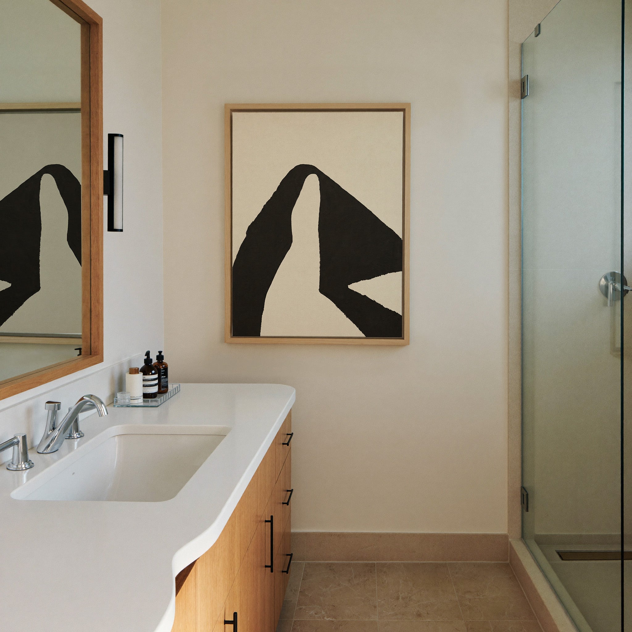 black and cream abstract with canvas wall art in a natural wood frame in a styled room setting