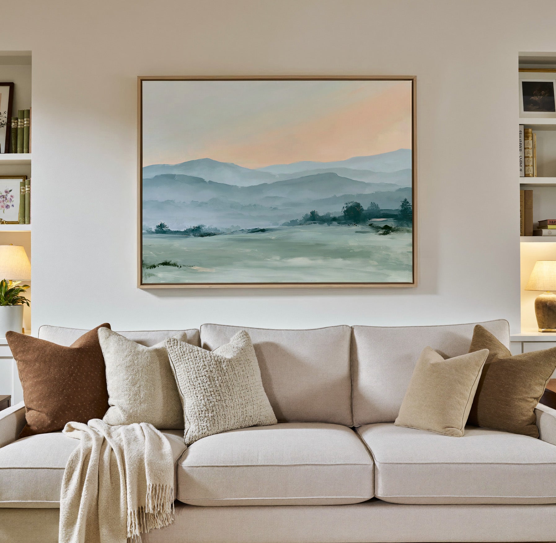 misty blue hills with a peach sky canvas wall art in a natural wood frame in a styled room setting