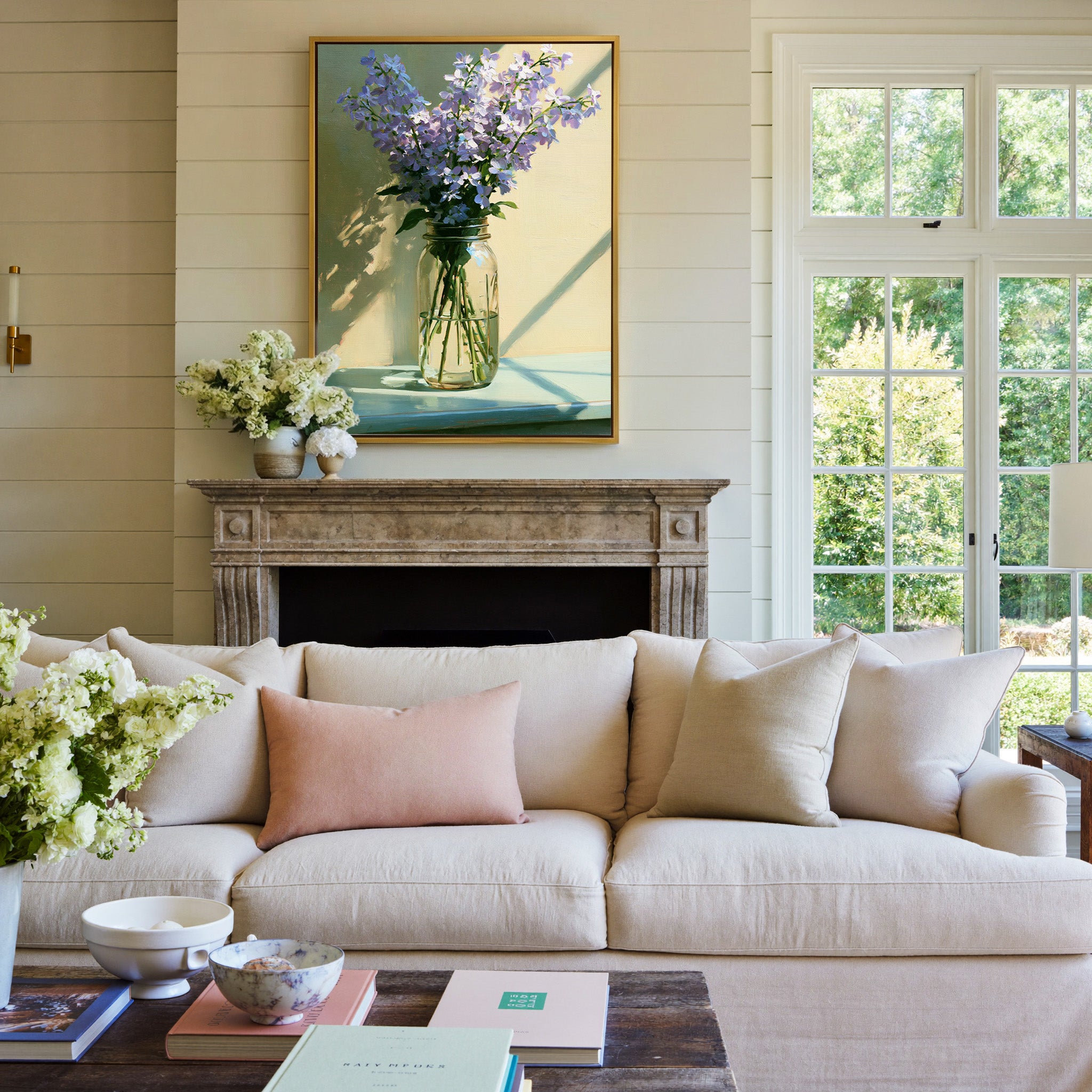 pale lavender flowers in a glass jar with soft canvas wall art in a gold frame above a mantel