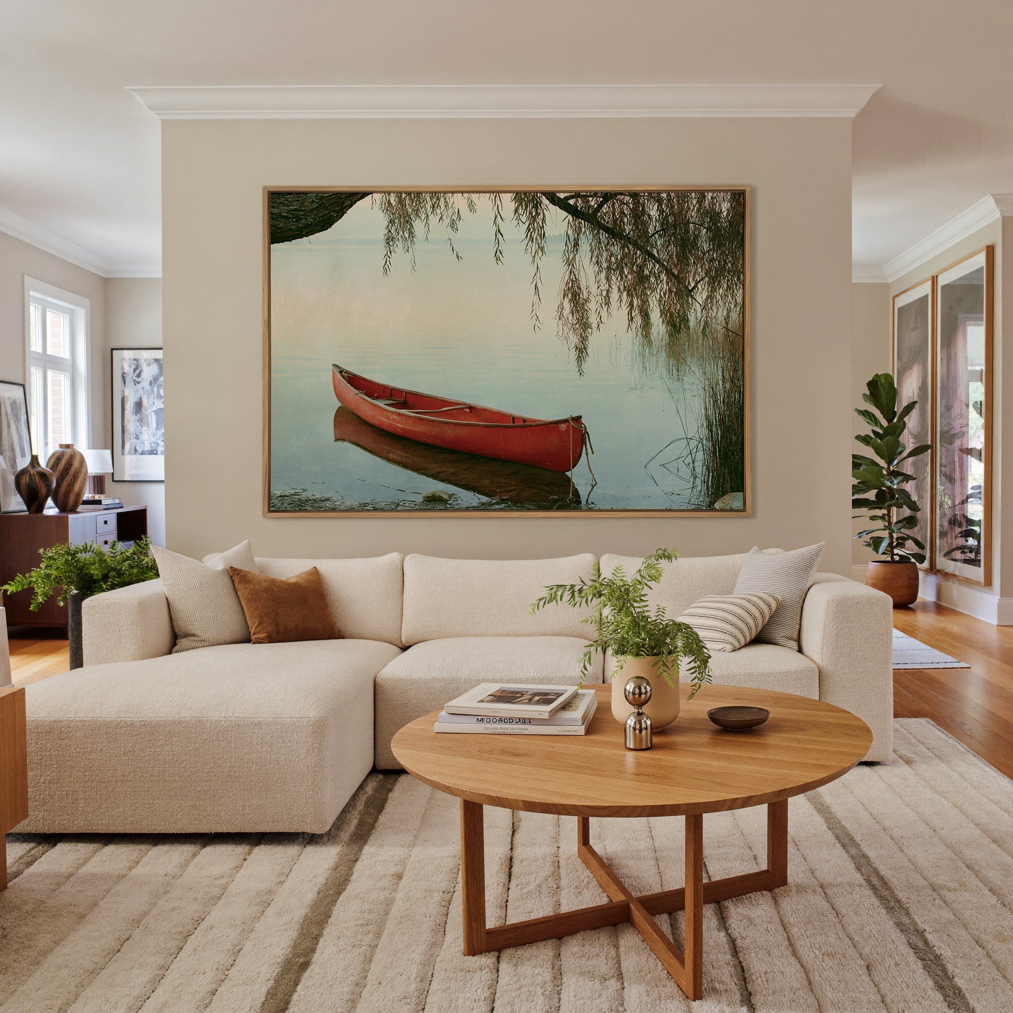red canoe under hanging willow branches by canvas wall art in an oak frame in a living room