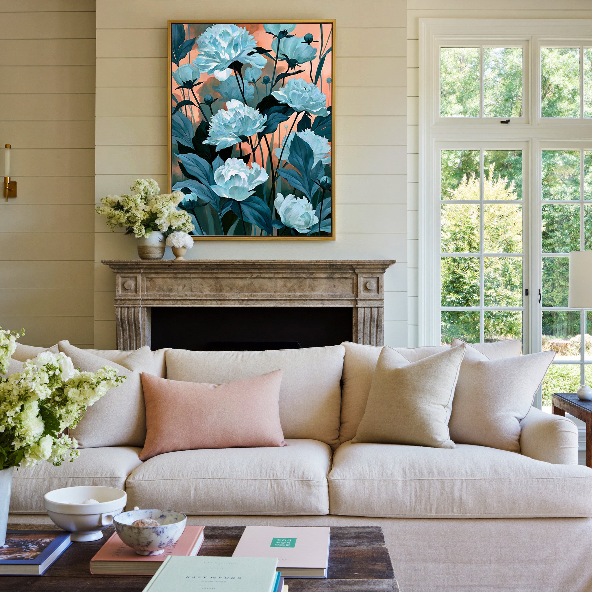 white flowers with teal leaves on a coral dusk canvas wall art in a gold frame above a mantel