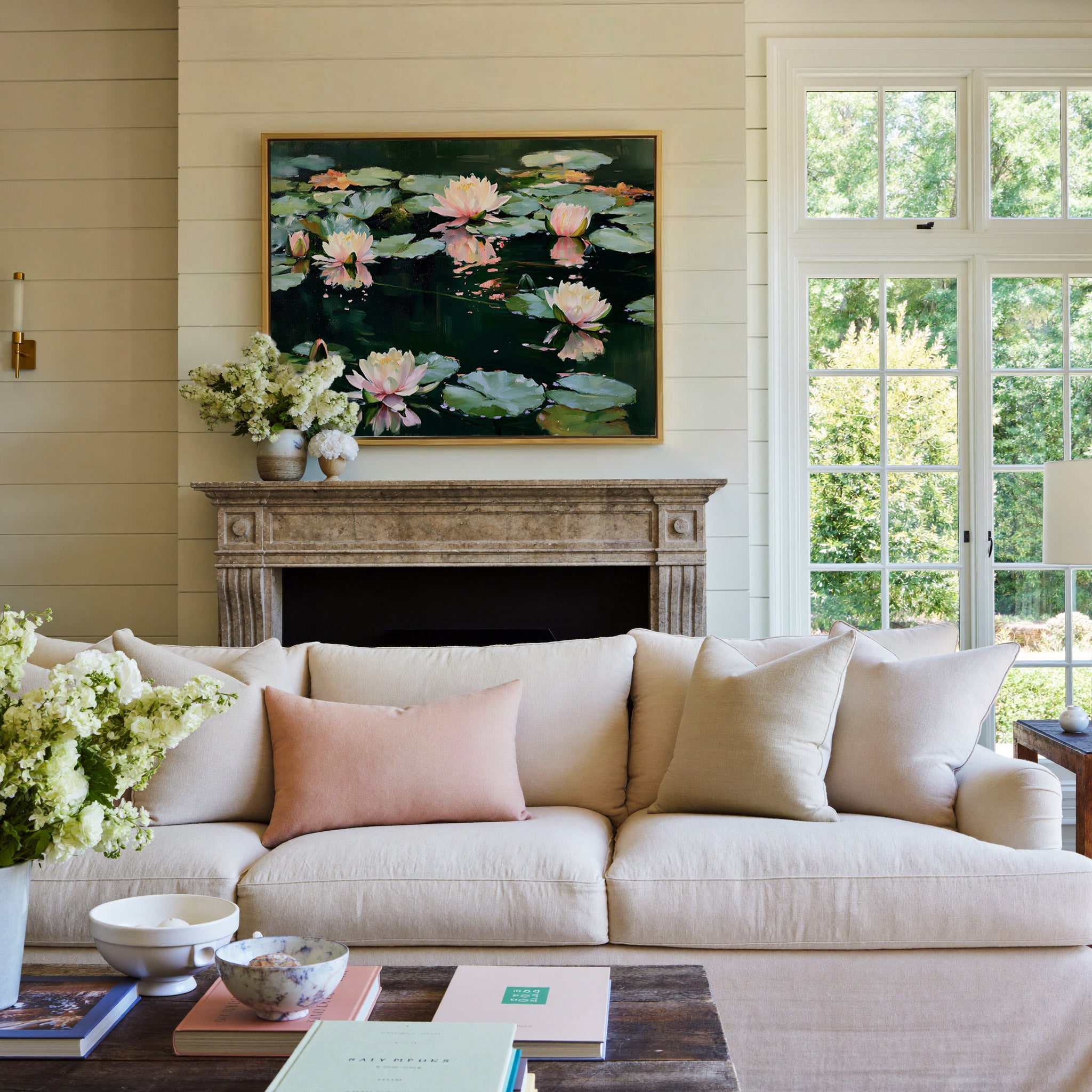pink and white water lilies on dark green water canvas wall art in a gold frame above a mantel