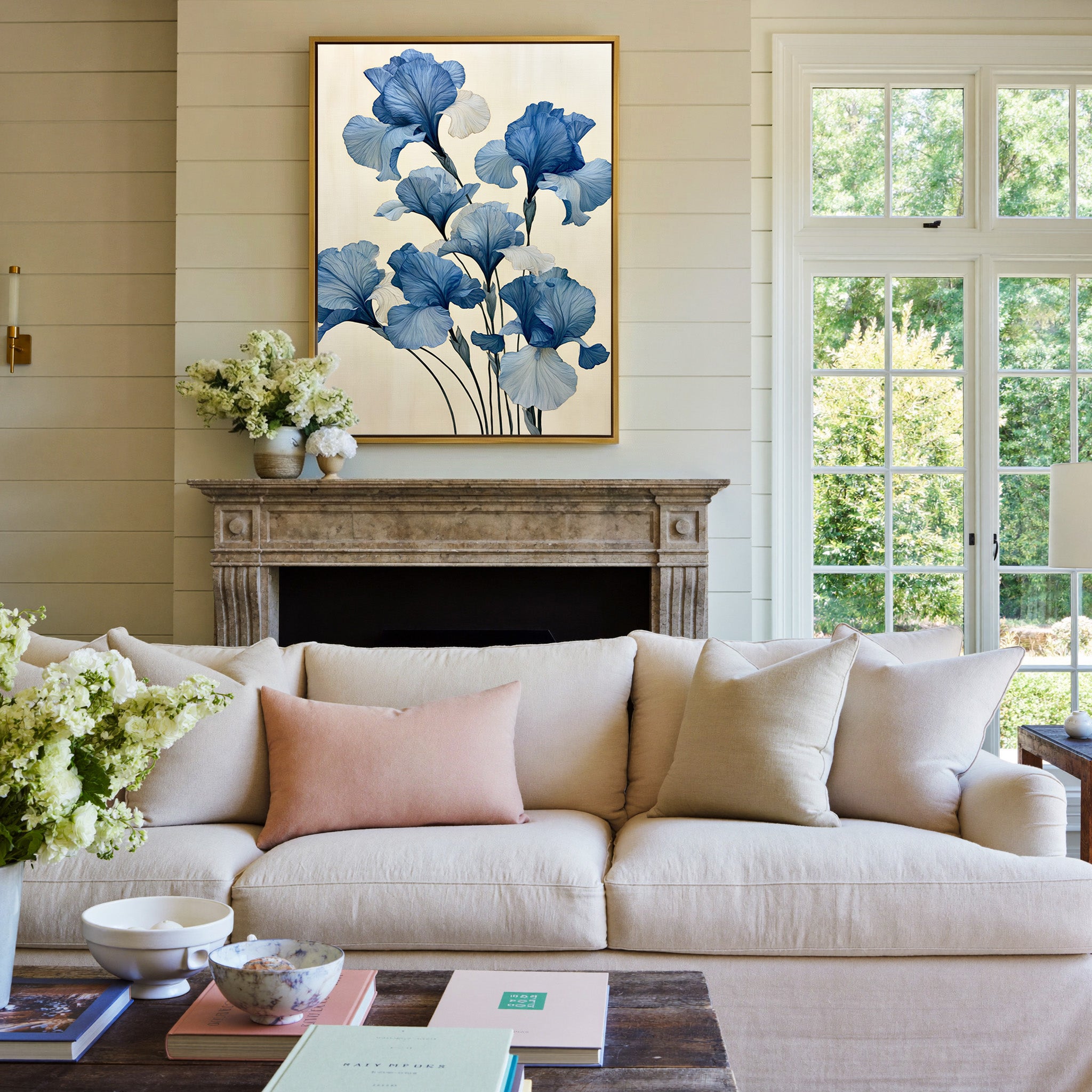 oversized blue iris flowers on a pale cream canvas wall art in a gold frame above a mantel