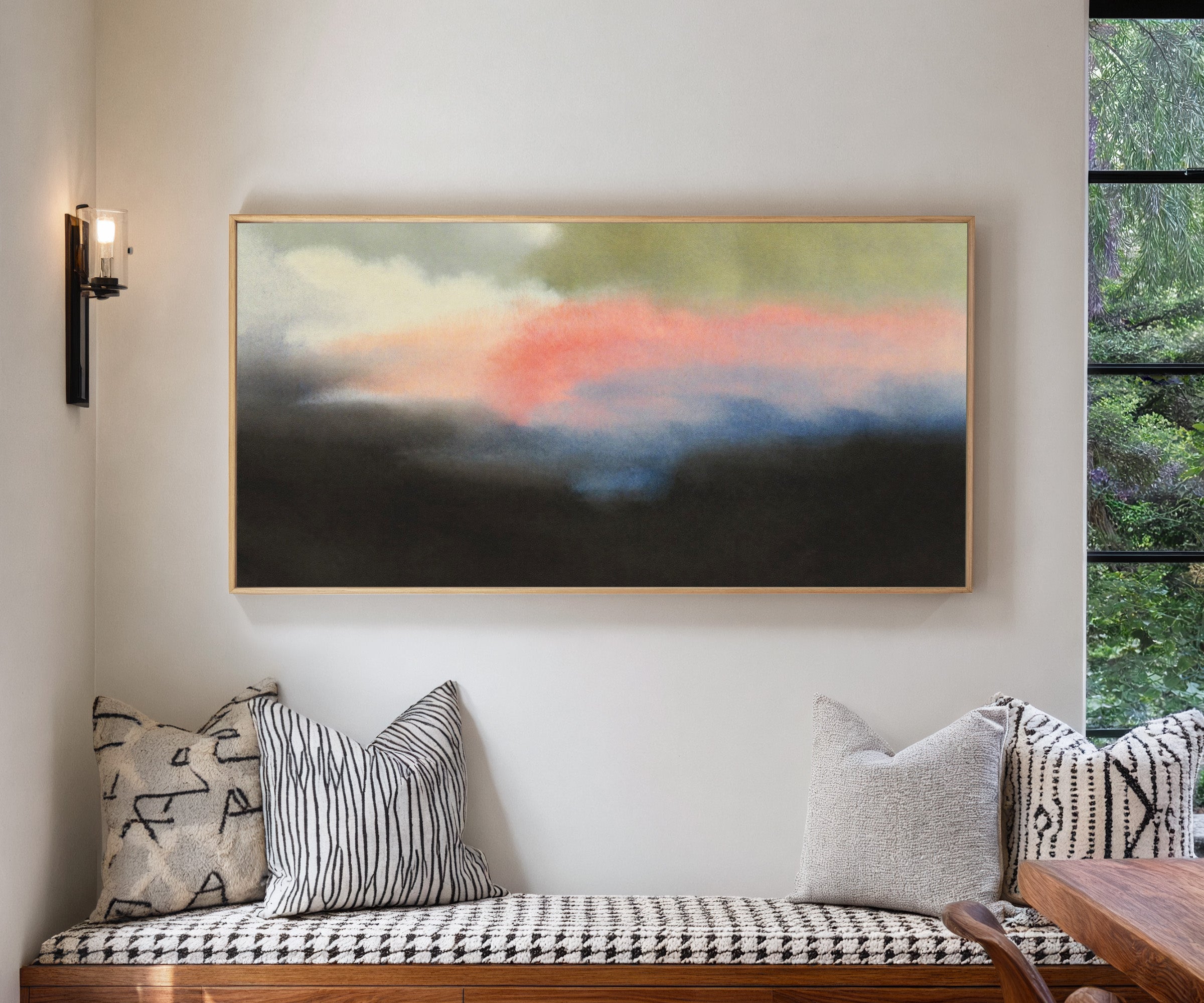 soft pink and blue abstract with dark grounding canvas wall art in a natural wood frame in a living room