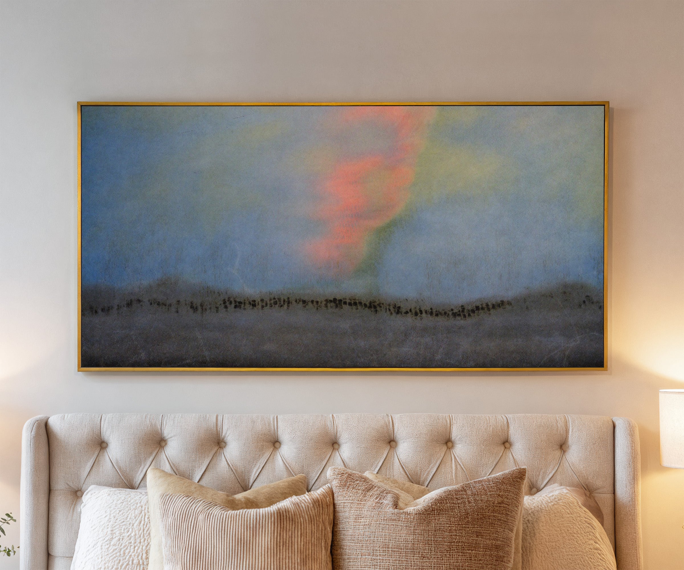 soft blue abstract with coral glow and dark canvas wall art in a gold frame above a bed