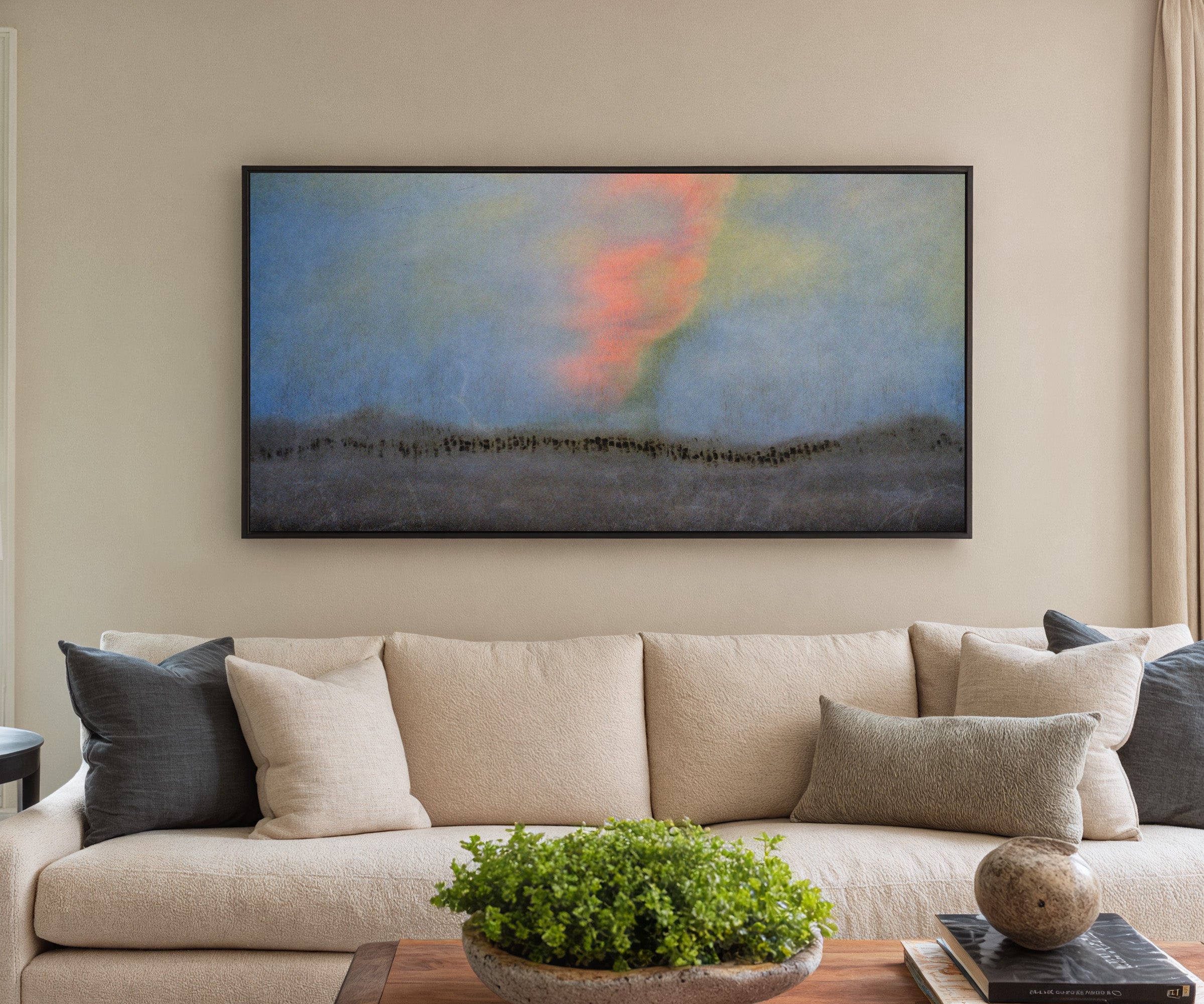 soft blue abstract with coral glow and dark canvas wall art in a black frame in a styled room setting
