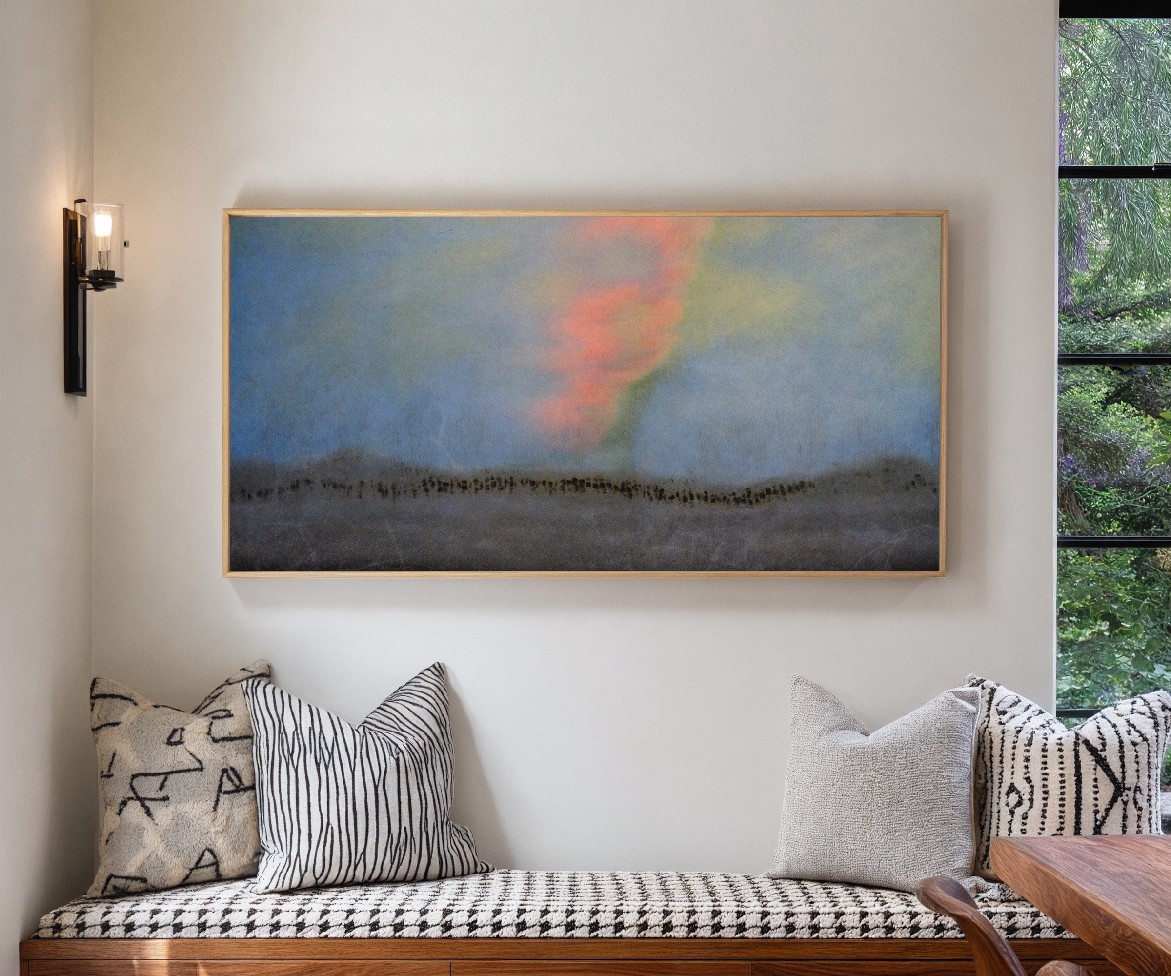 soft blue abstract with coral glow and dark canvas wall art in a natural wood frame in a living room