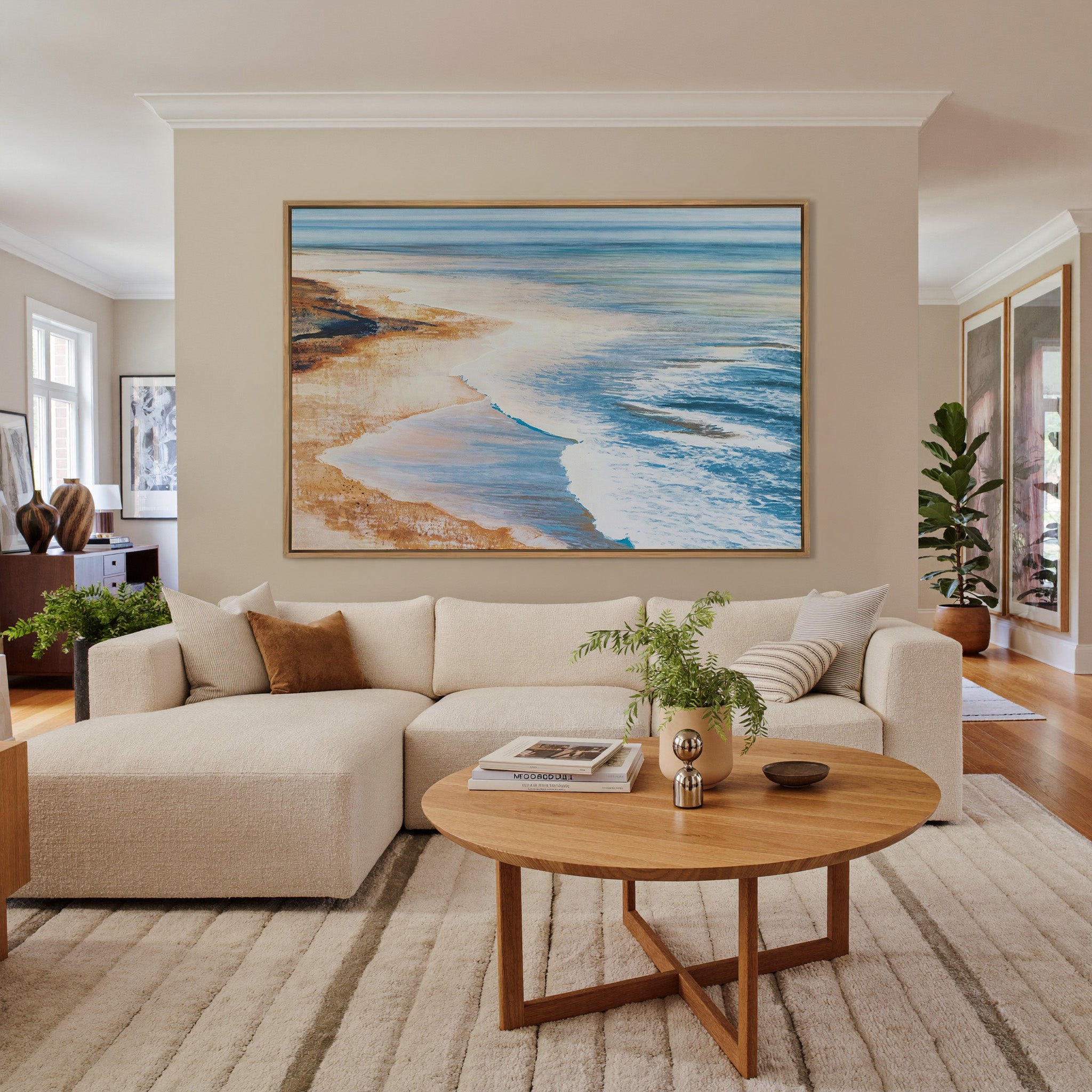blue water meeting warm sand canvas wall art in an oak frame in a living room