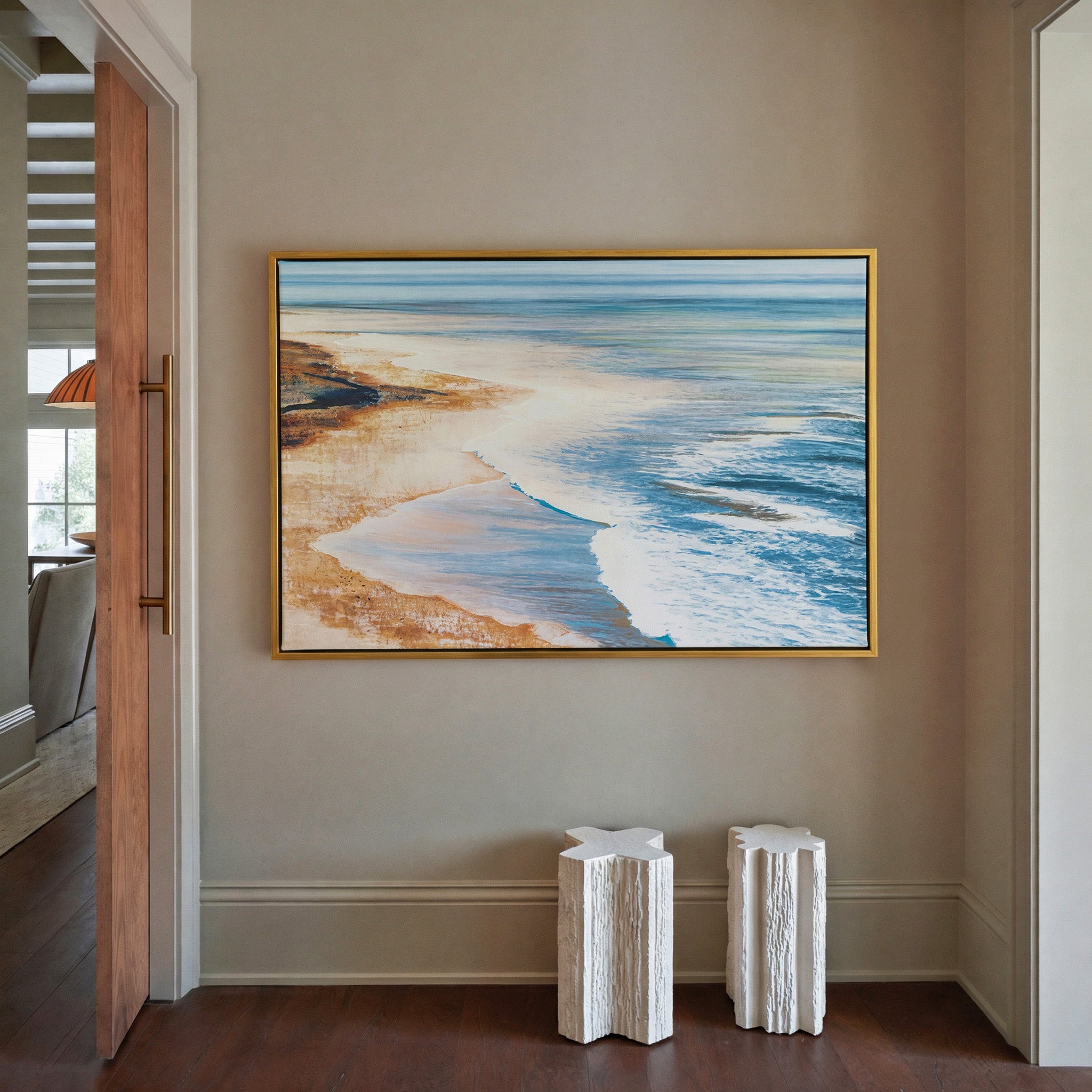 blue water meeting warm sand canvas wall art in a gold frame in a styled room setting