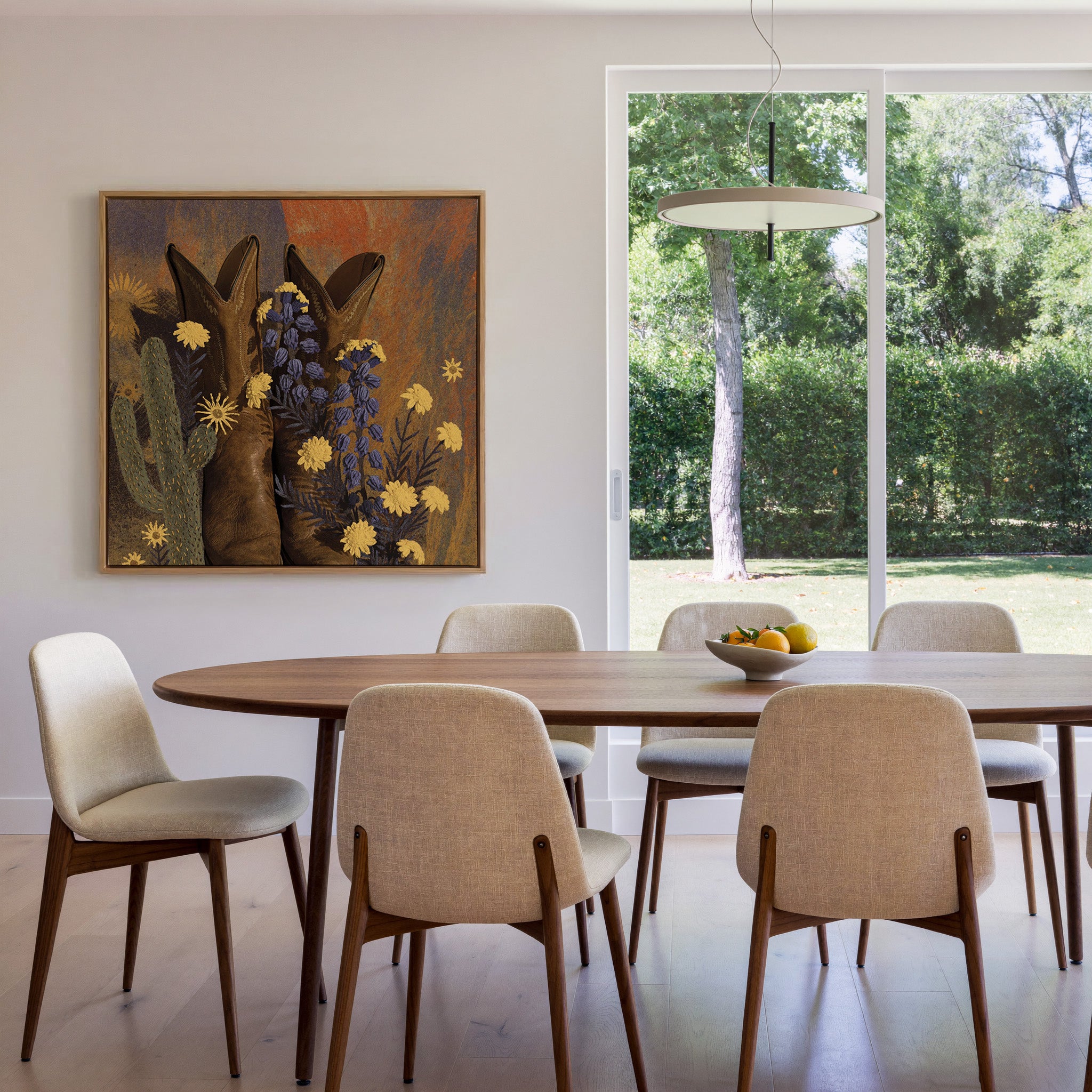 brown boots with yellow and blue wildflowers canvas wall art in an oak frame in a dining room