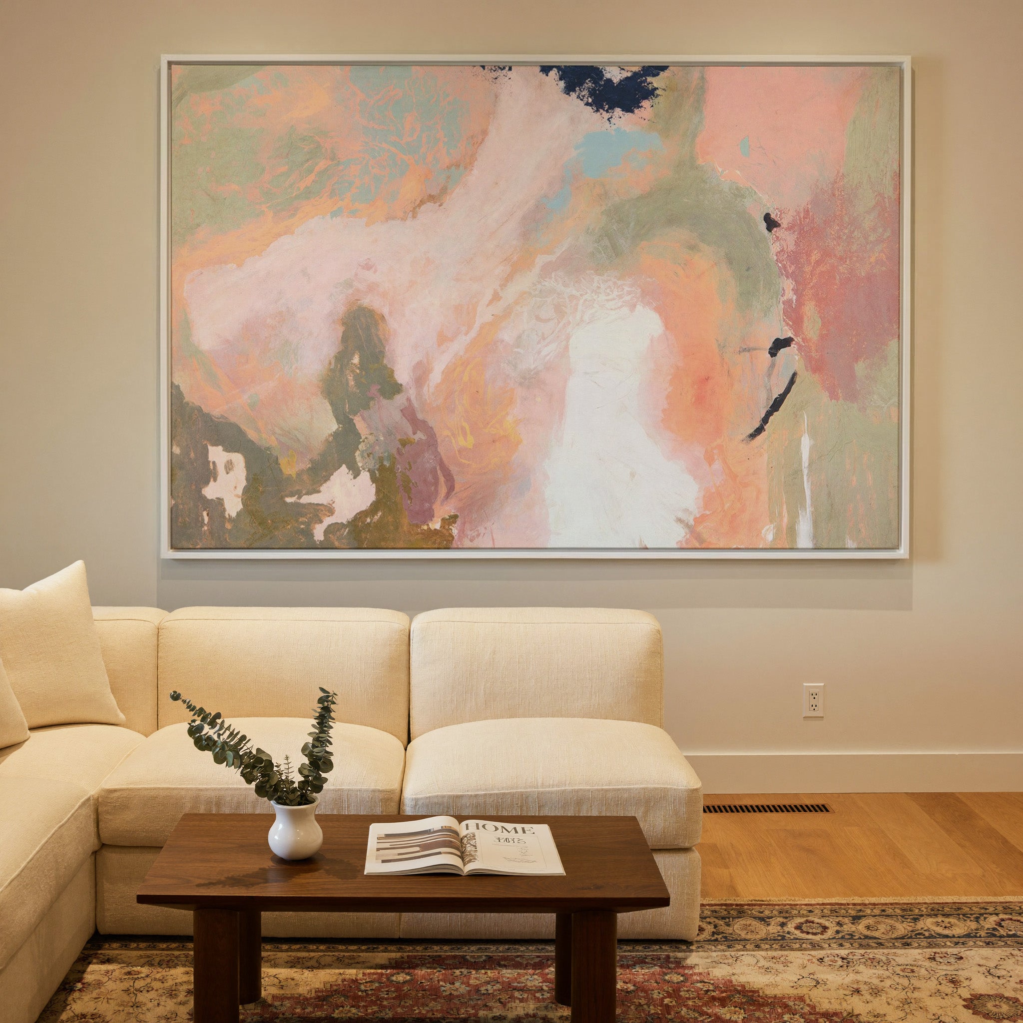 soft peach, sage, and cream abstract with dark canvas wall art in a white frame in a styled room setting