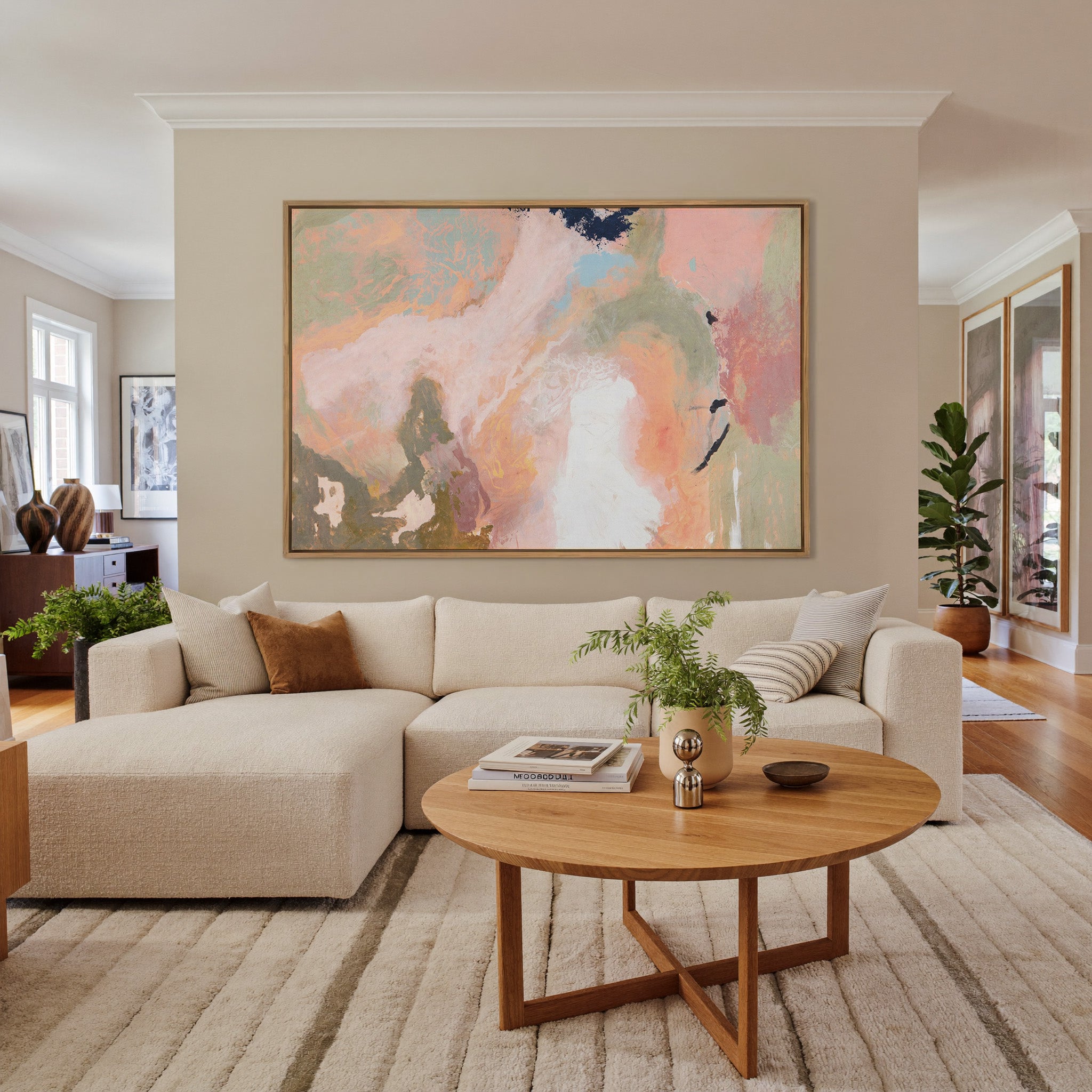soft peach, sage, and cream abstract with dark canvas wall art in an oak frame in a living room