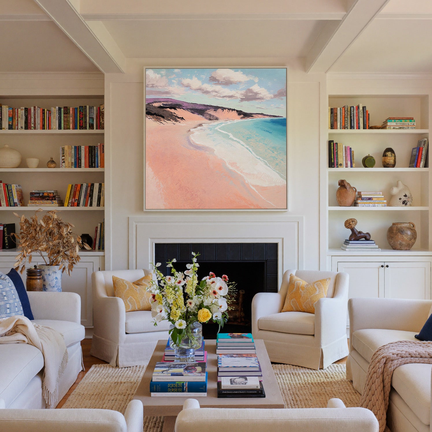 soft peach beach with turquoise water and canvas wall art in a white frame above a fireplace