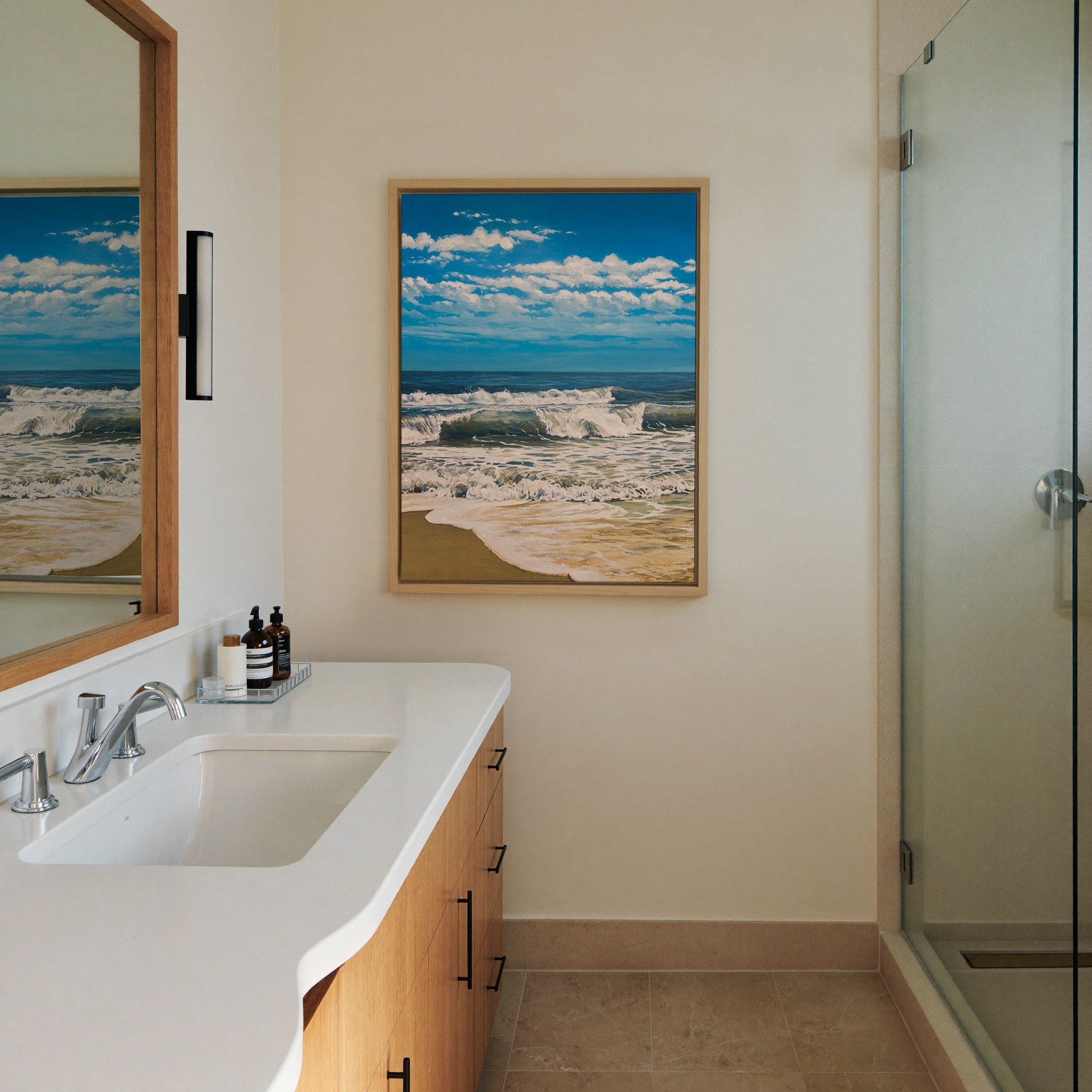 bright blue seascape with foamy canvas wall art in a natural wood frame in a styled room setting