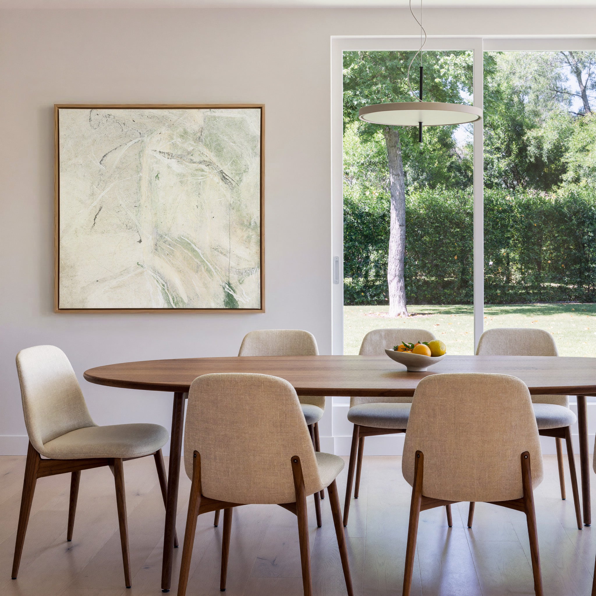 soft cream abstract with pale green sweeps and canvas wall art in an oak frame in a dining room