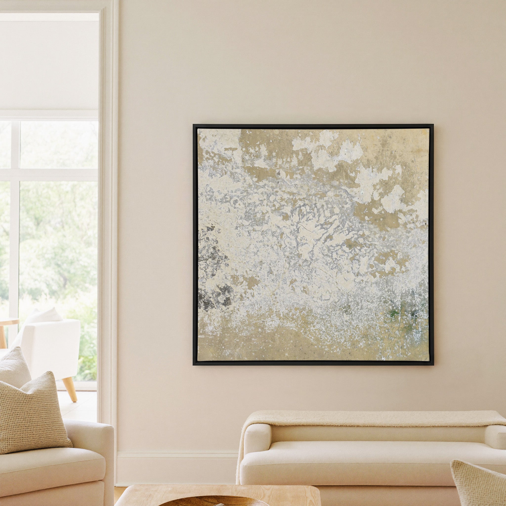 weathered cream and taupe abstract canvas wall art in a black frame in a living room