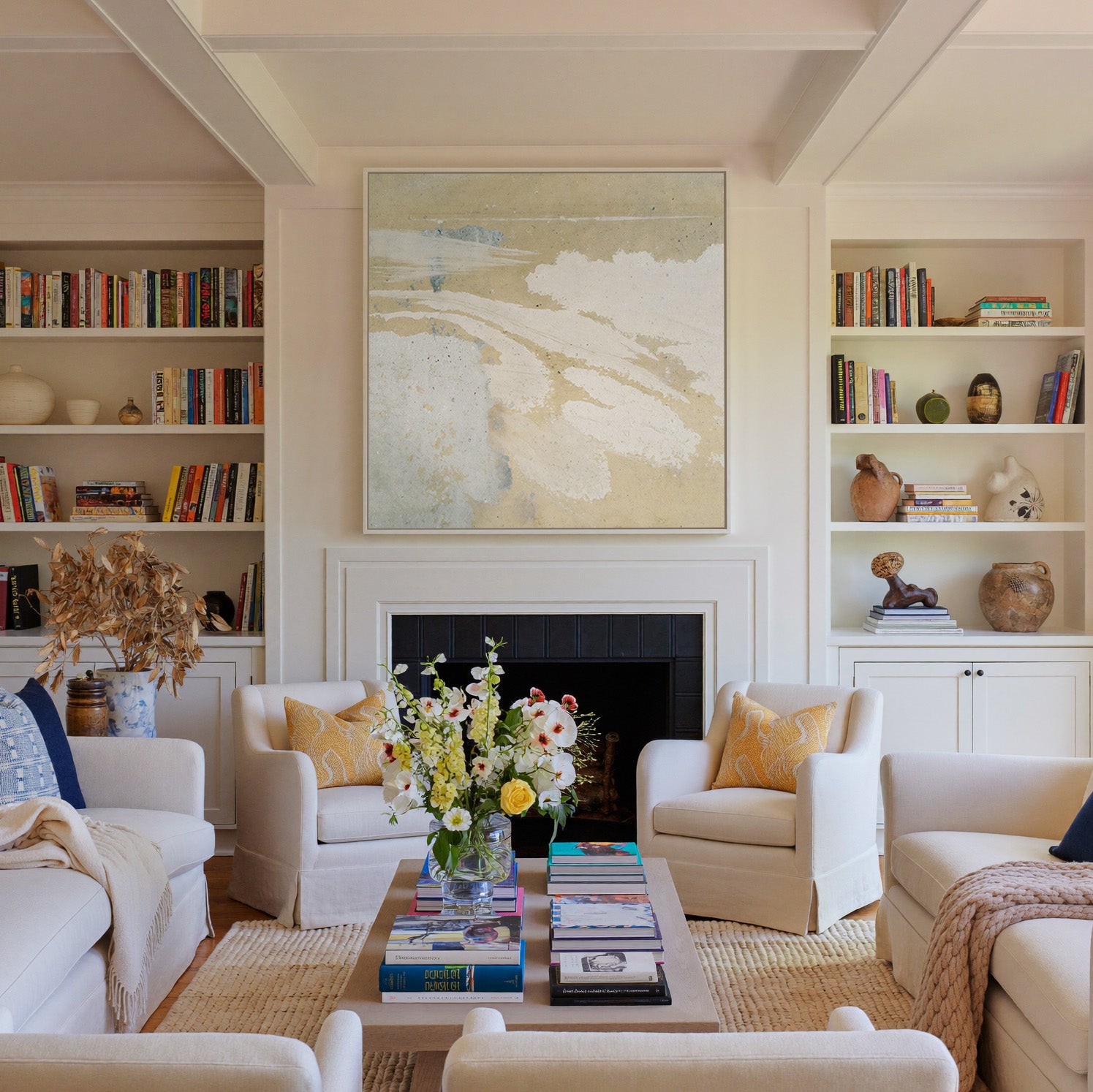 cream and sand abstract with pale blue streaks canvas wall art in a white frame above a fireplace