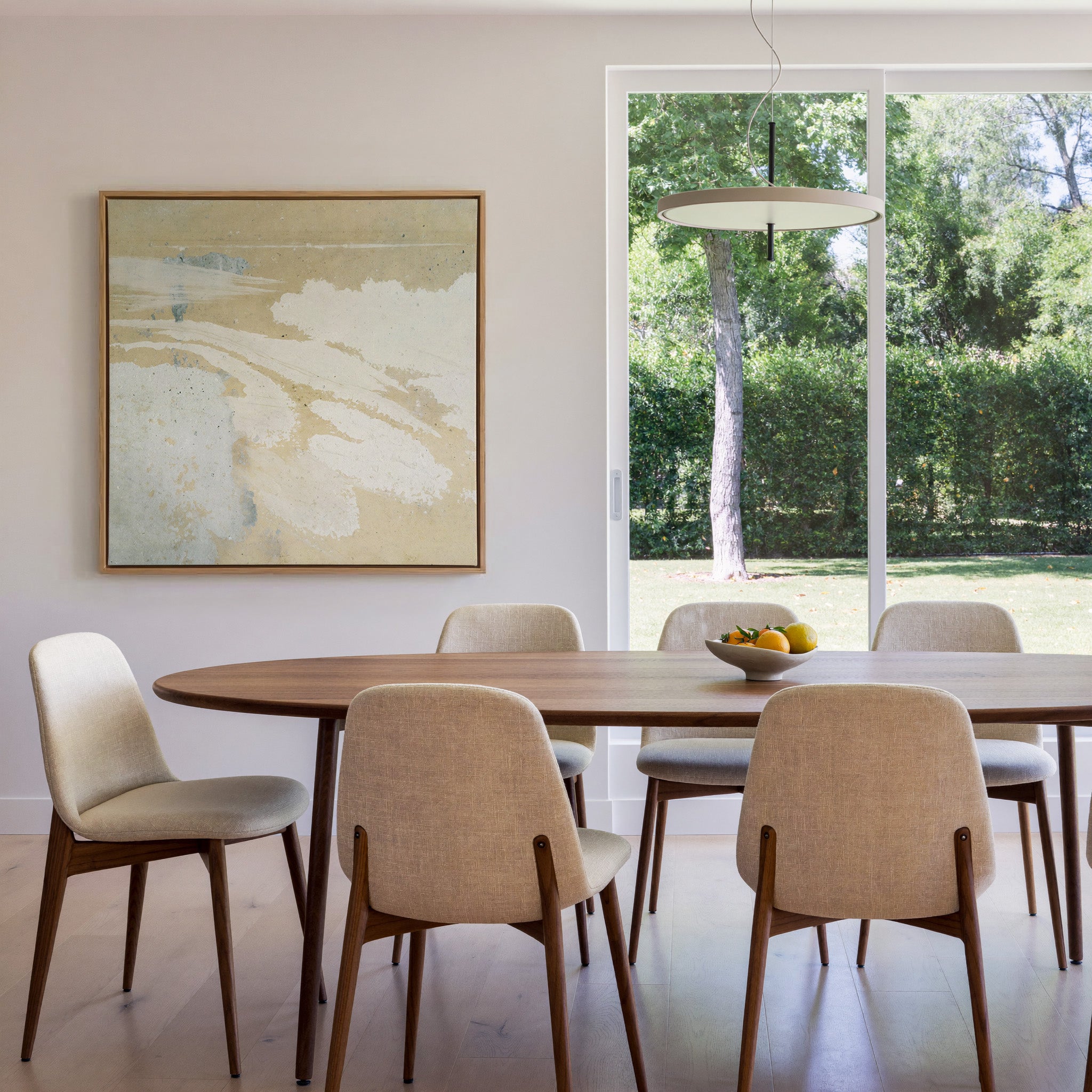 cream and sand abstract with pale blue streaks canvas wall art in an oak frame in a dining room