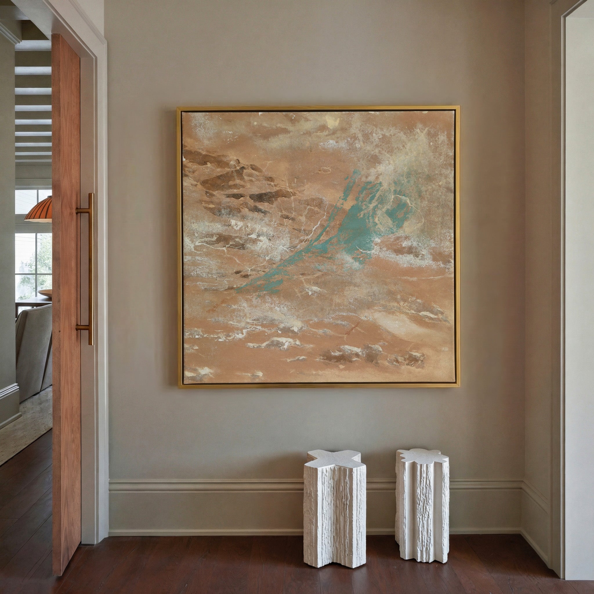 warm tan abstract with turquoise streaks and canvas wall art in a gold frame in a styled room setting