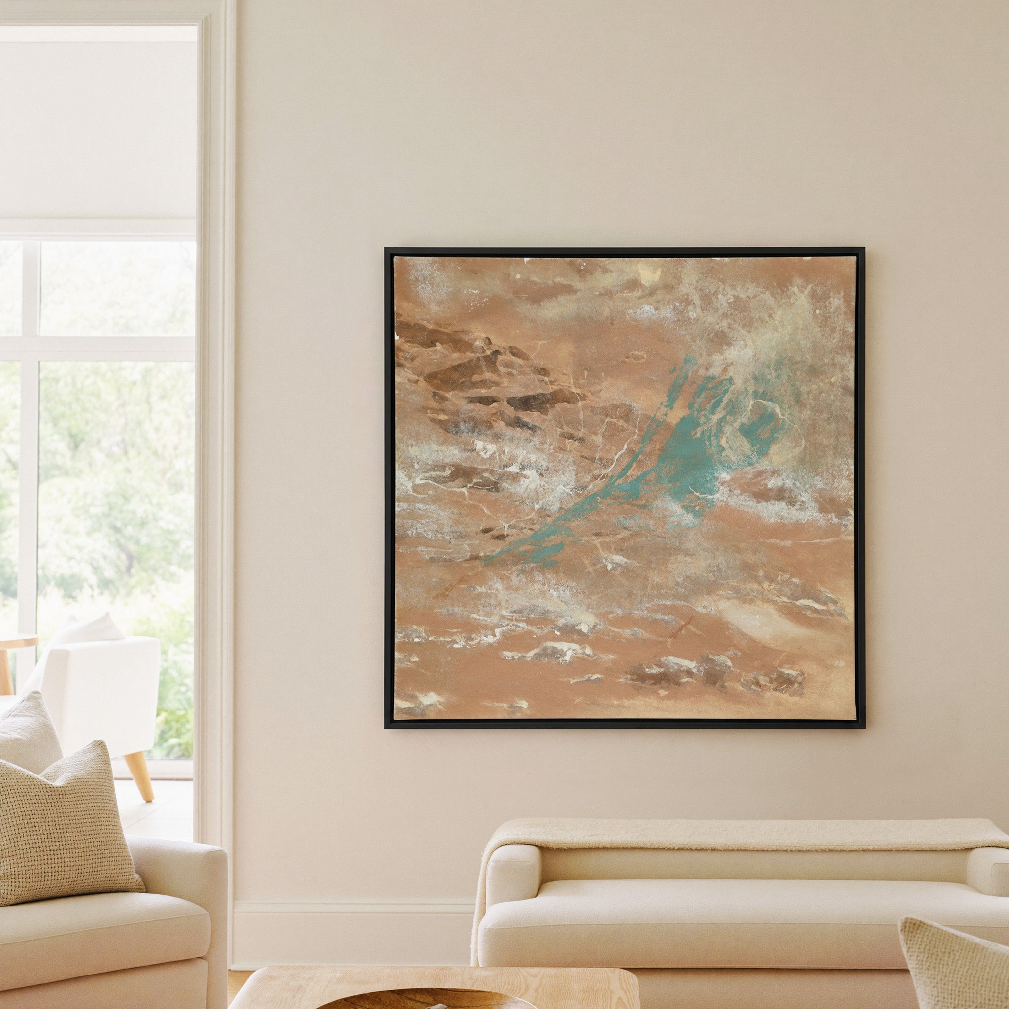 warm tan abstract with turquoise streaks and canvas wall art in a black frame in a living room