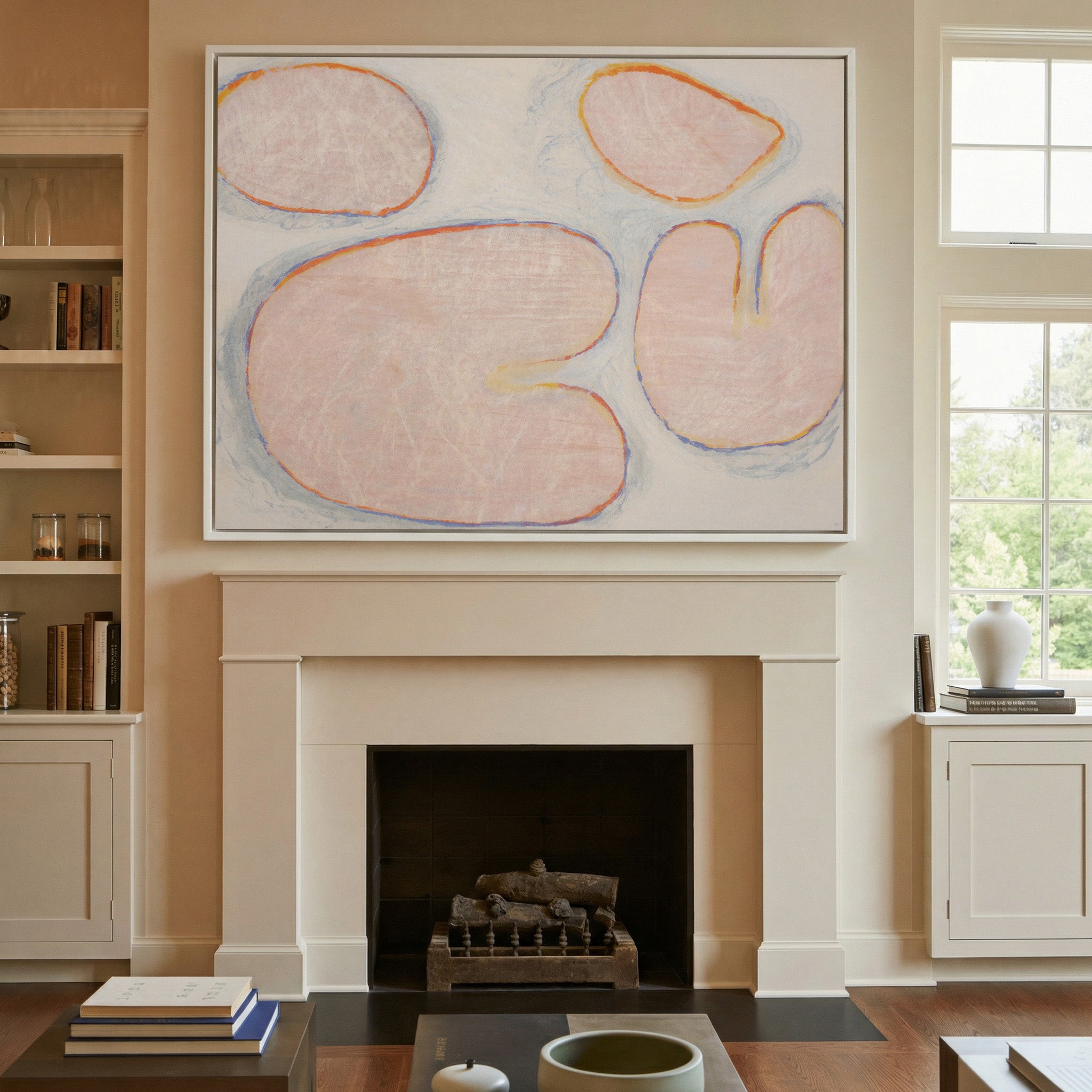 pale blush abstract with rounded forms and blue canvas wall art in a white frame above a mantel