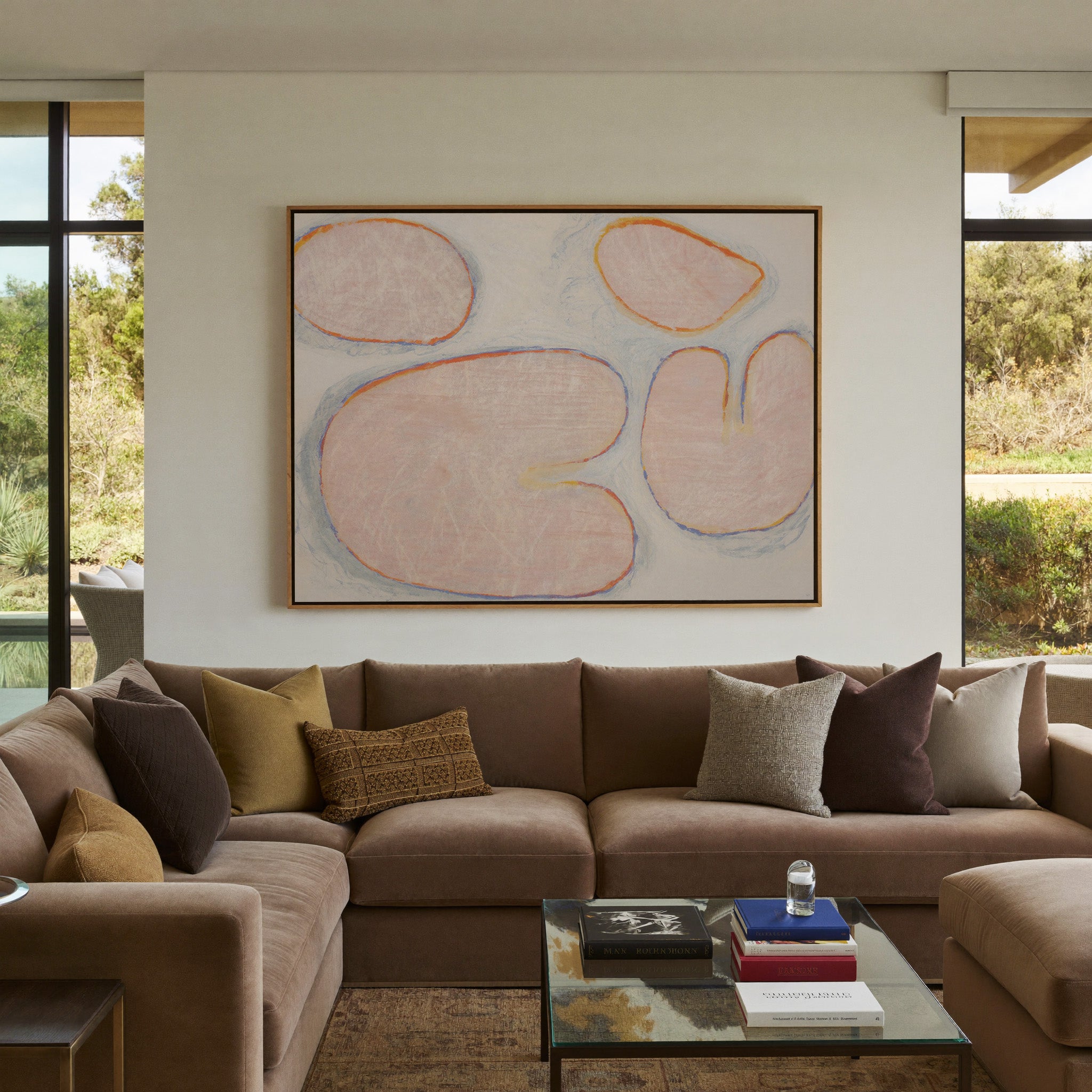 pale blush abstract with rounded forms and blue canvas wall art in an oak frame in a styled room setting