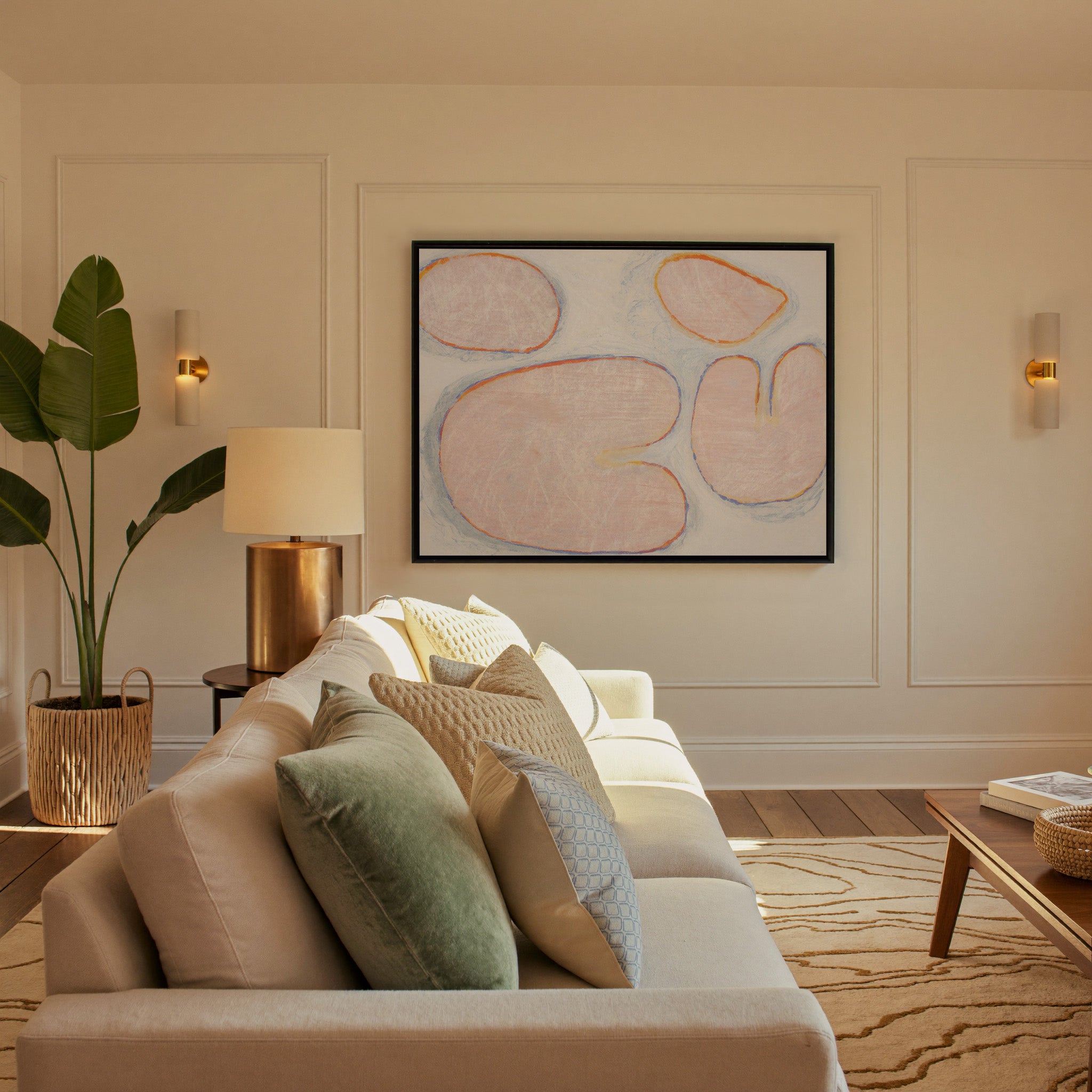 pale blush abstract with rounded forms and blue canvas wall art in a black frame in a styled room setting
